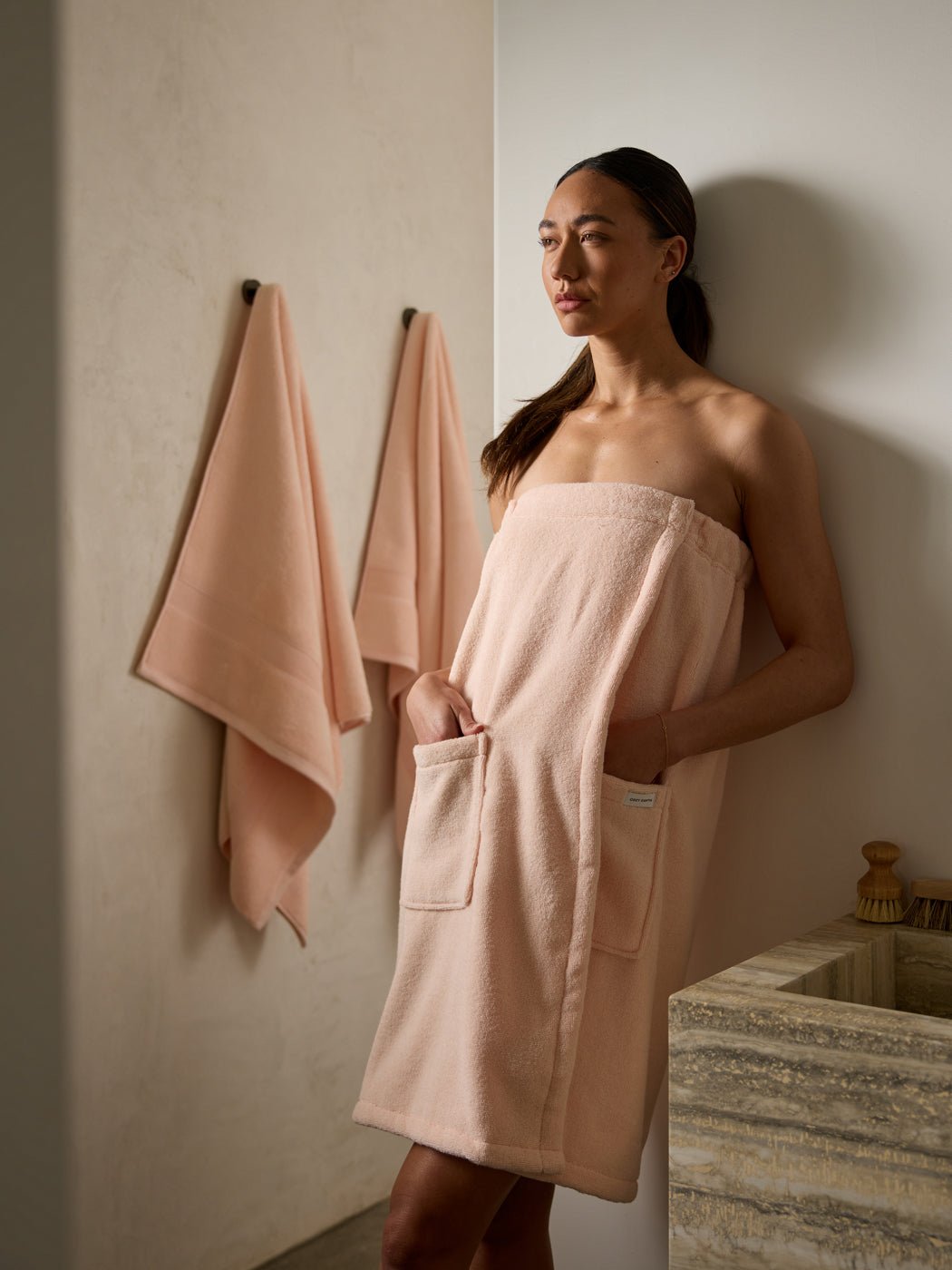 Woman in bathroom wearing pink towel wrap 