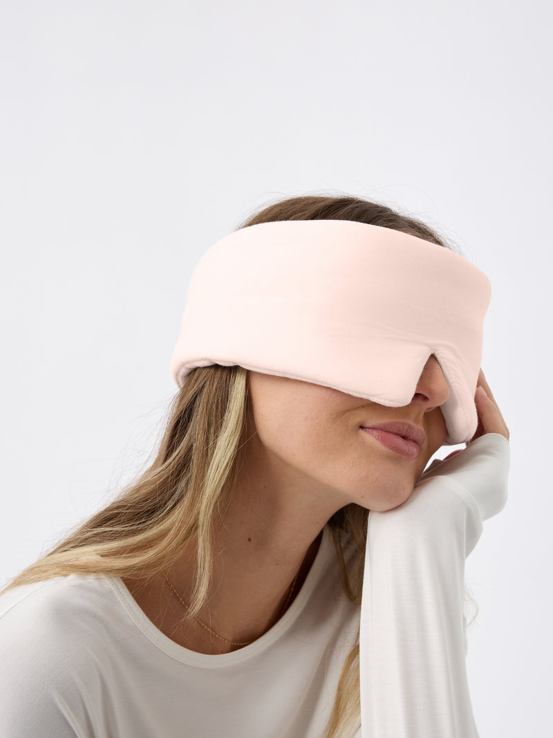 A woman wears the Cozy Earth Adjustable Bamboo Sleep Mask in Blossom.