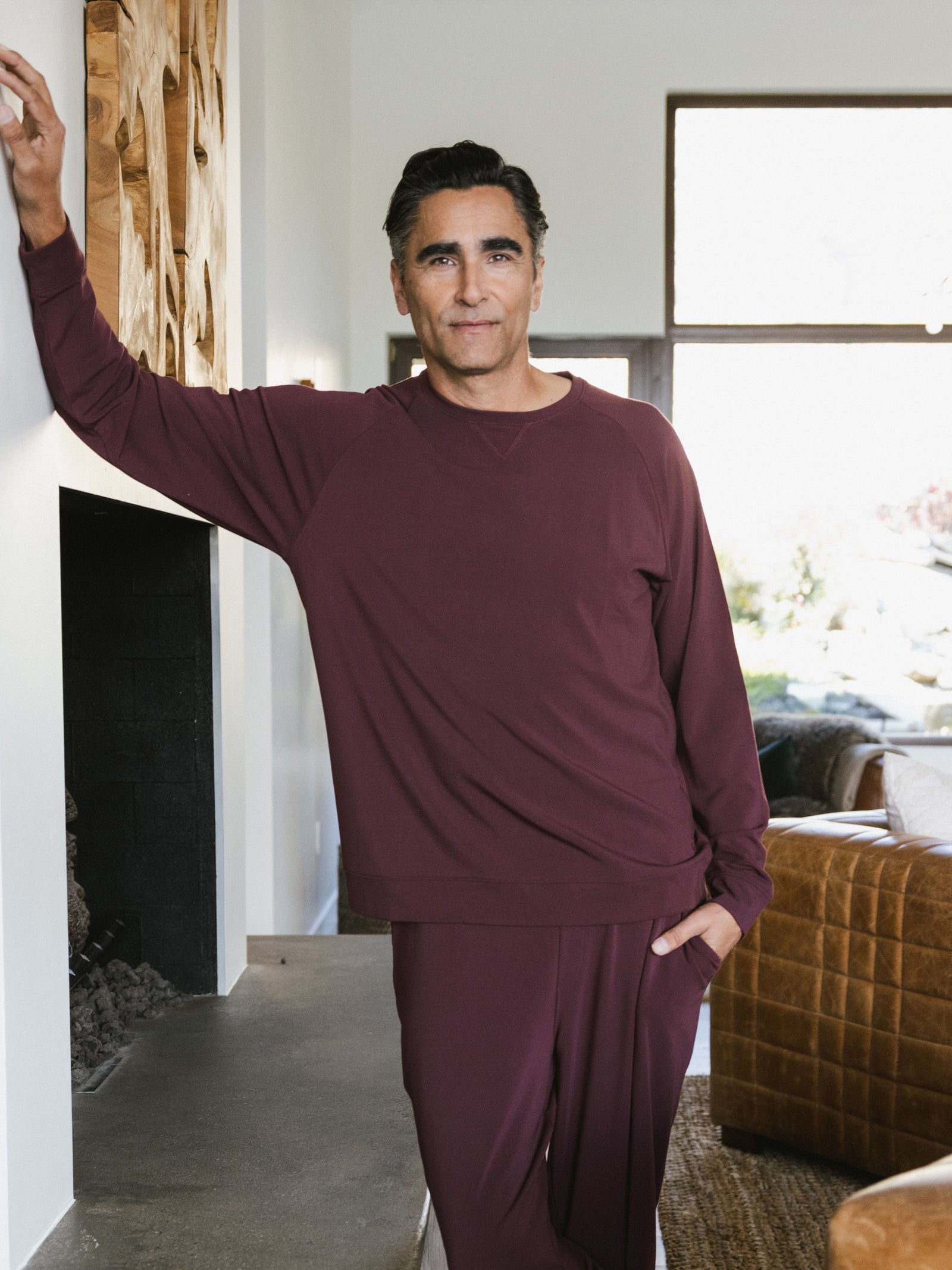 Burgundy Men's Bamboo Jogger Set. There is a man wearing the jogger set. He is standing in a well lit room in a home.