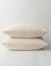 Two Aire Bamboo Shams by Cozy Earth, in a soft cream color, are stacked on a white background, highlighting their smooth fabric and minimalist design.|Color:Buttermilk|Size:Standard