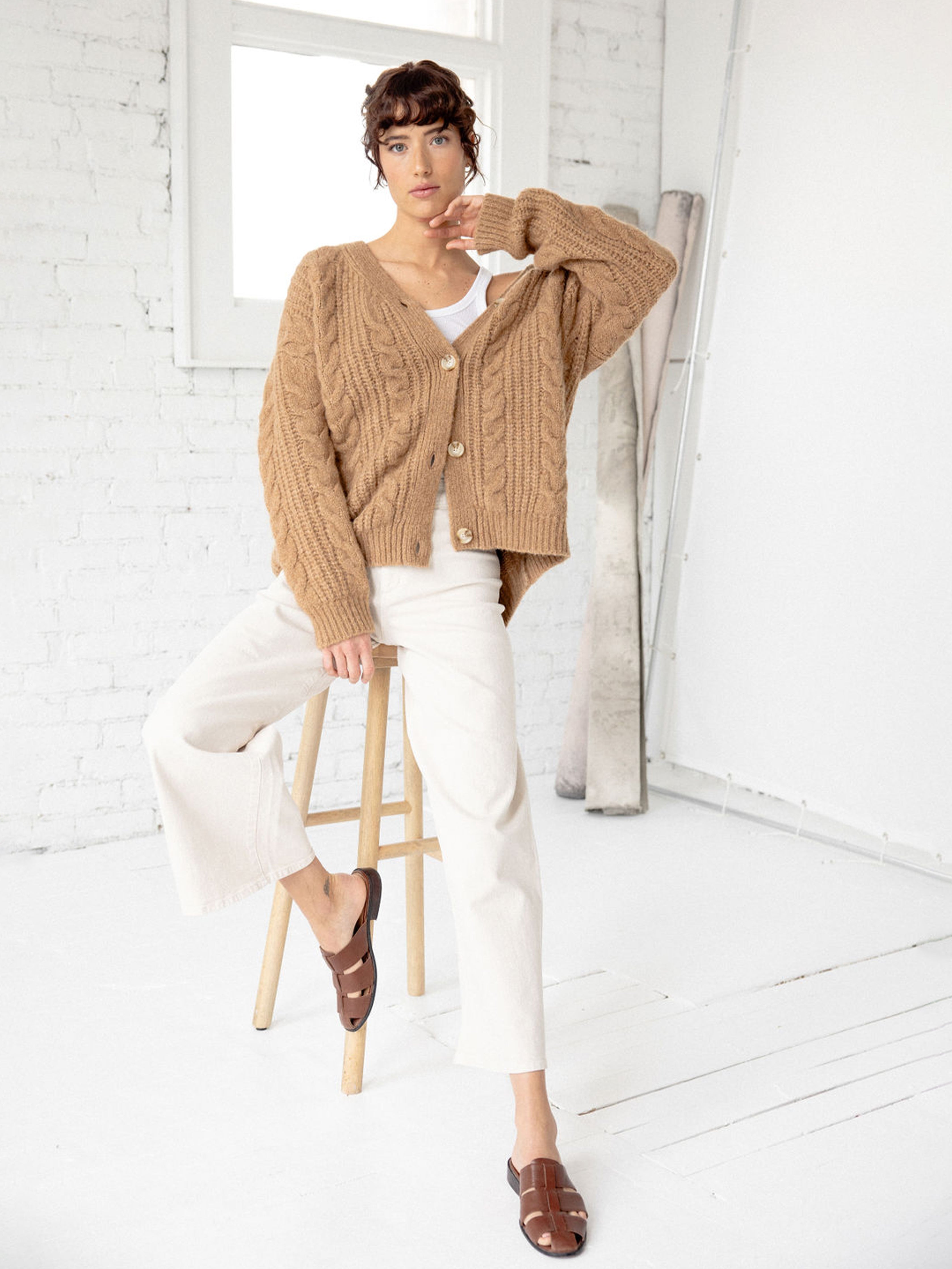 Woman sitting on wooden stool wearing camel cardigan |Color:Camel