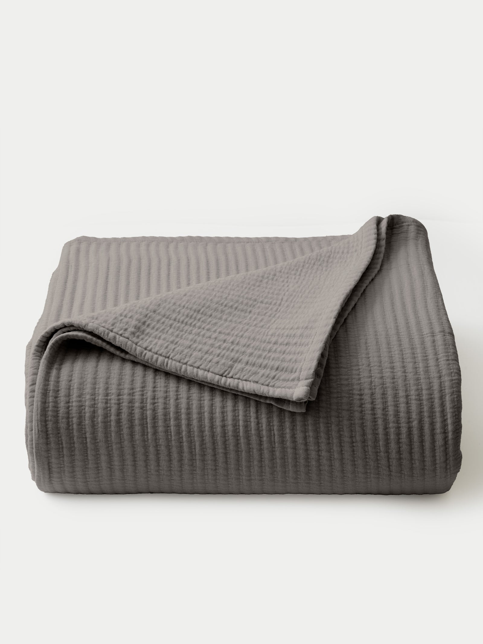 Charcoal coverlet folded with a white background 