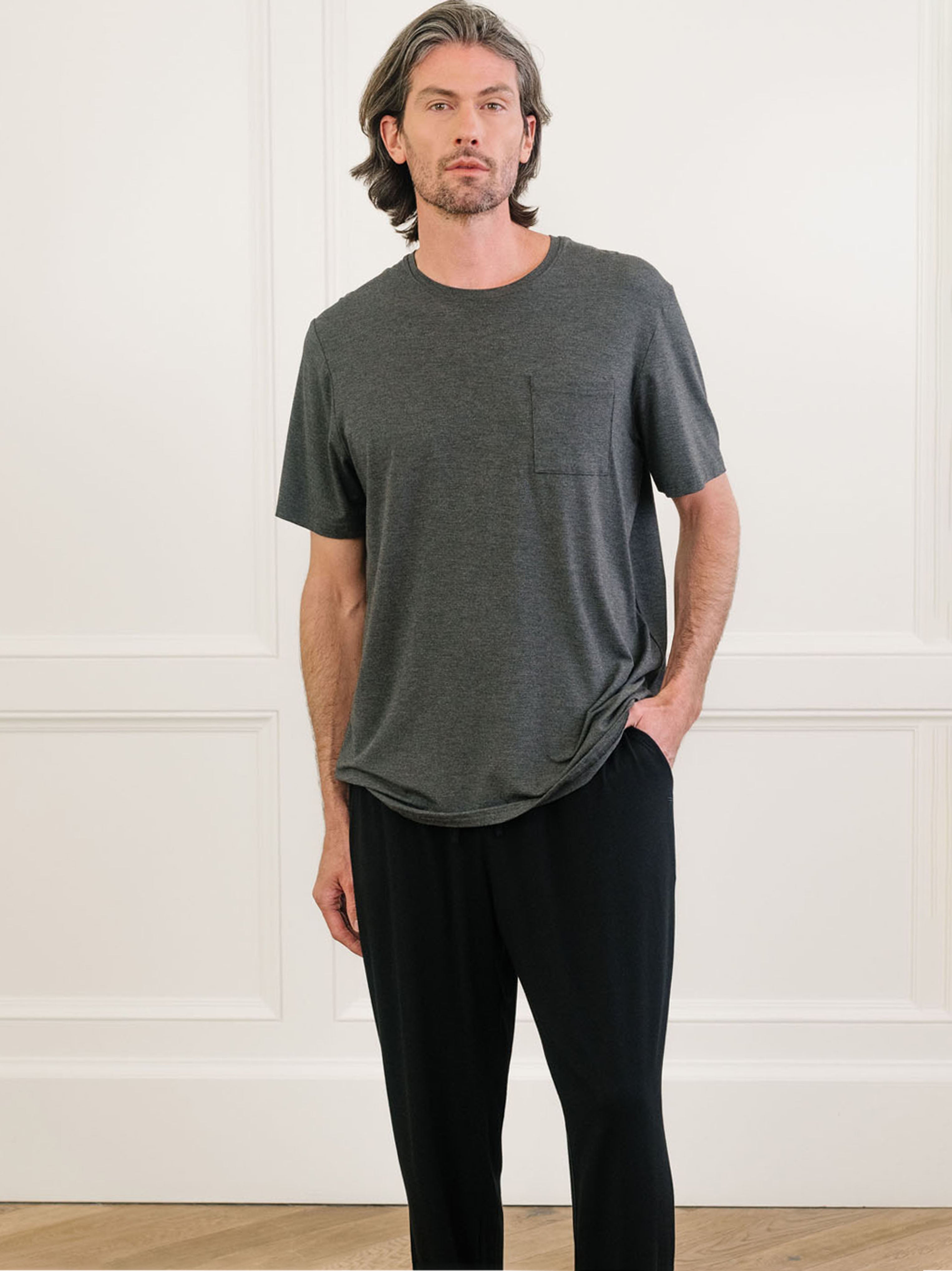 Charcoal Men's Stretch-Knit Bamboo Lounge Tee. A man is wearing the lounge tee in a well lit home.|Color:Charcoal