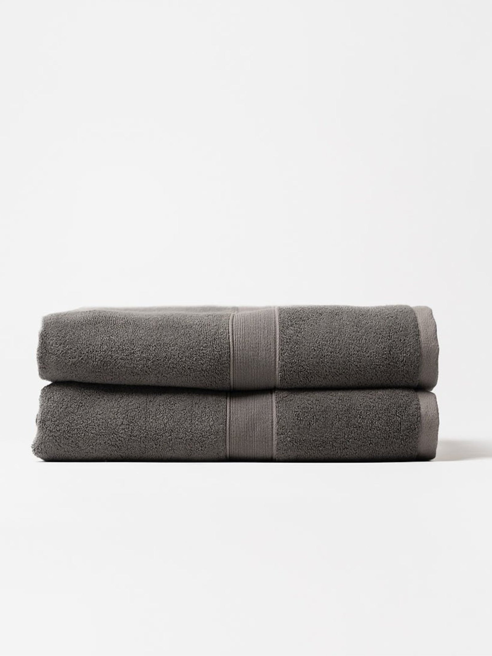 Two luxe bath sheets folded with white background 