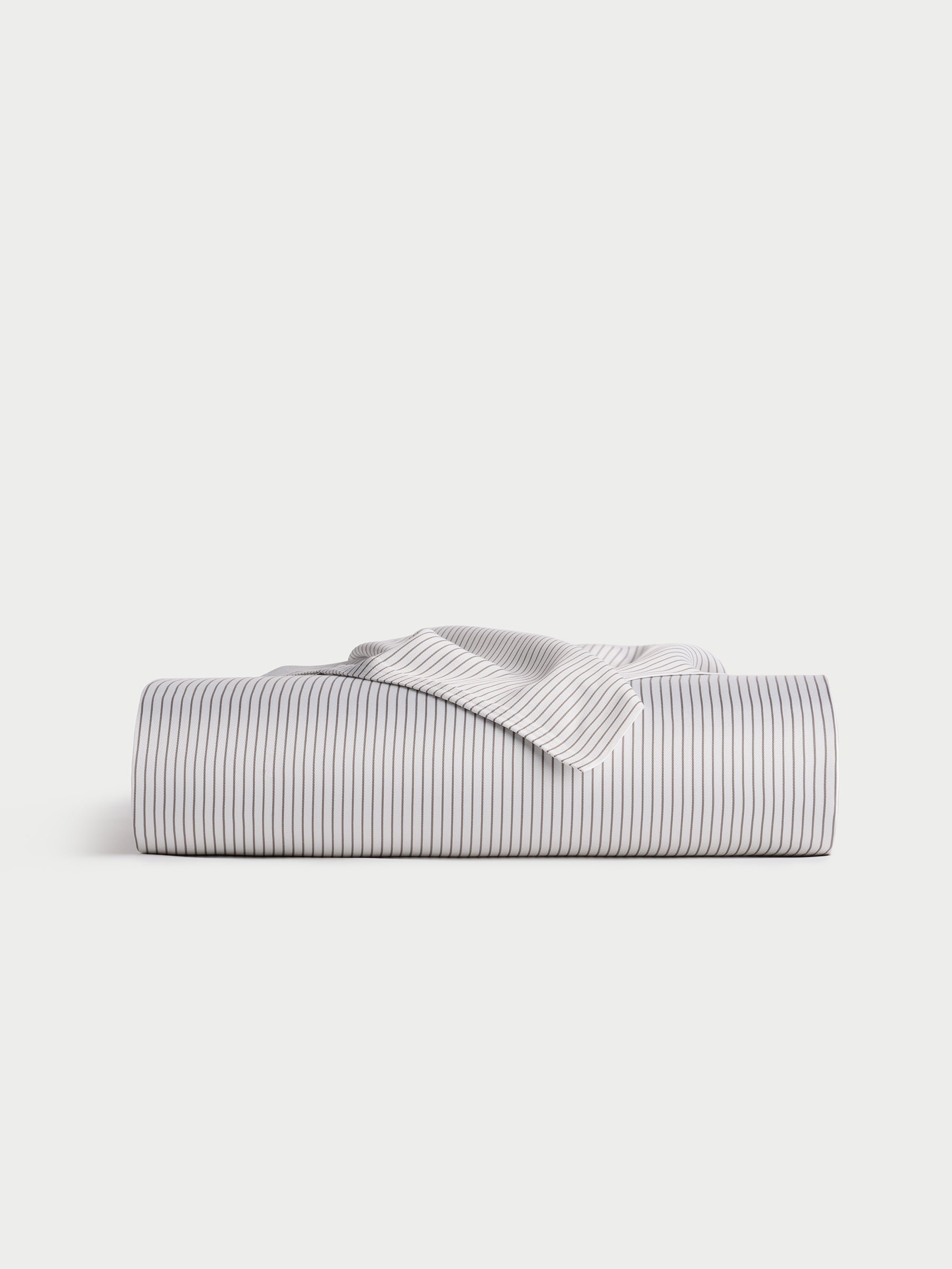 A neatly folded, horizontally positioned Bamboo Flat Sheet by Cozy Earth is displayed against a plain background, highlighting its white color with thin black stripes. |Color:Charcoal Pinstripe