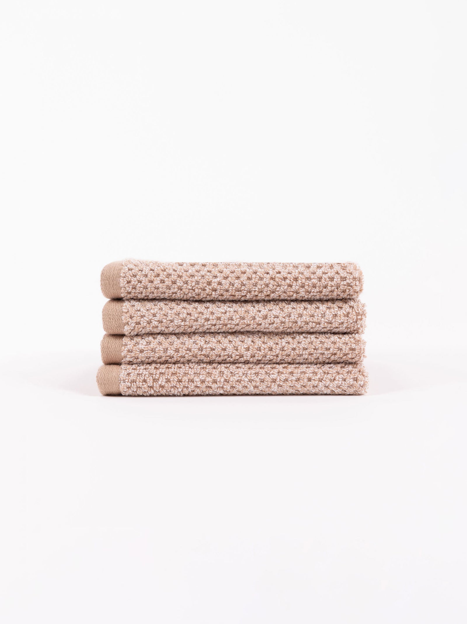 A stack of four Nantucket Washcloths in Heathered Clay sit in front of a white background. 