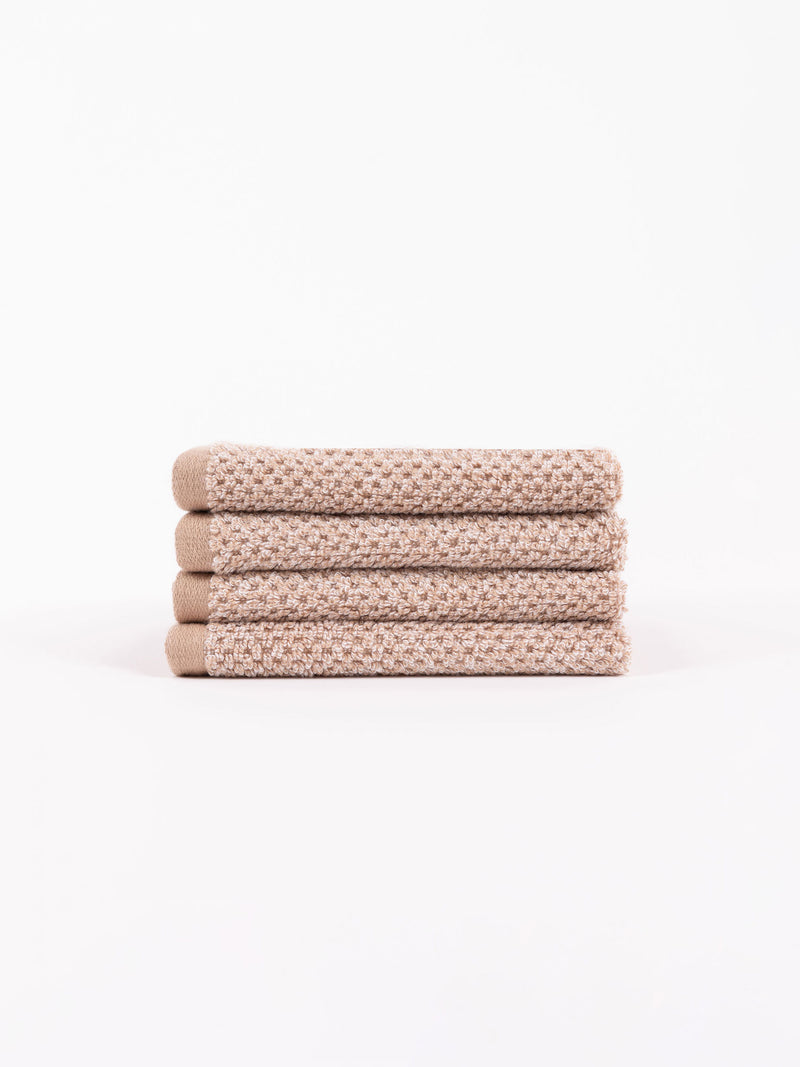 A stack of four Nantucket Washcloths in Heathered Clay sit in front of a white background.