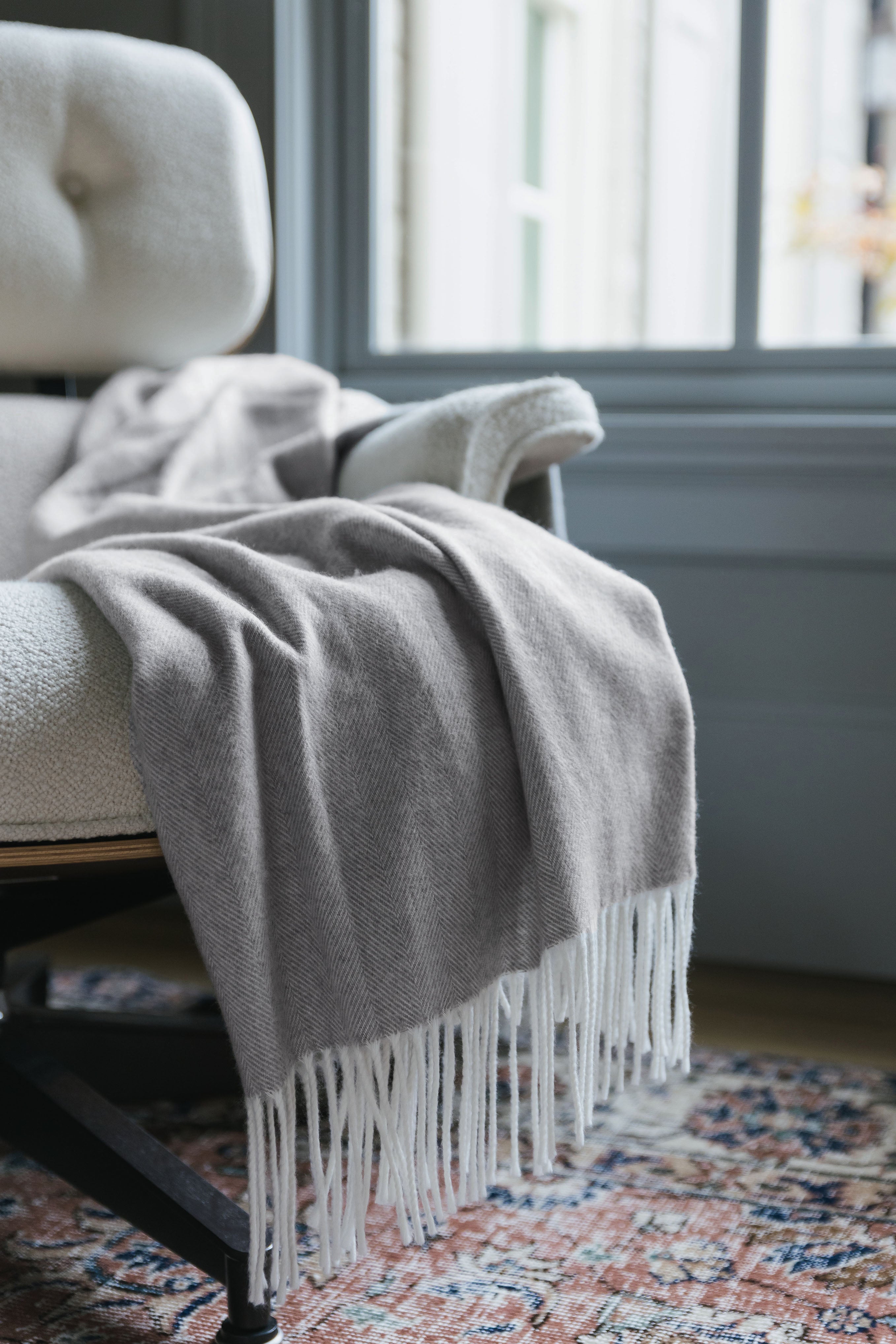 Cloud tassel throw laying on a chair |Color:Cloud