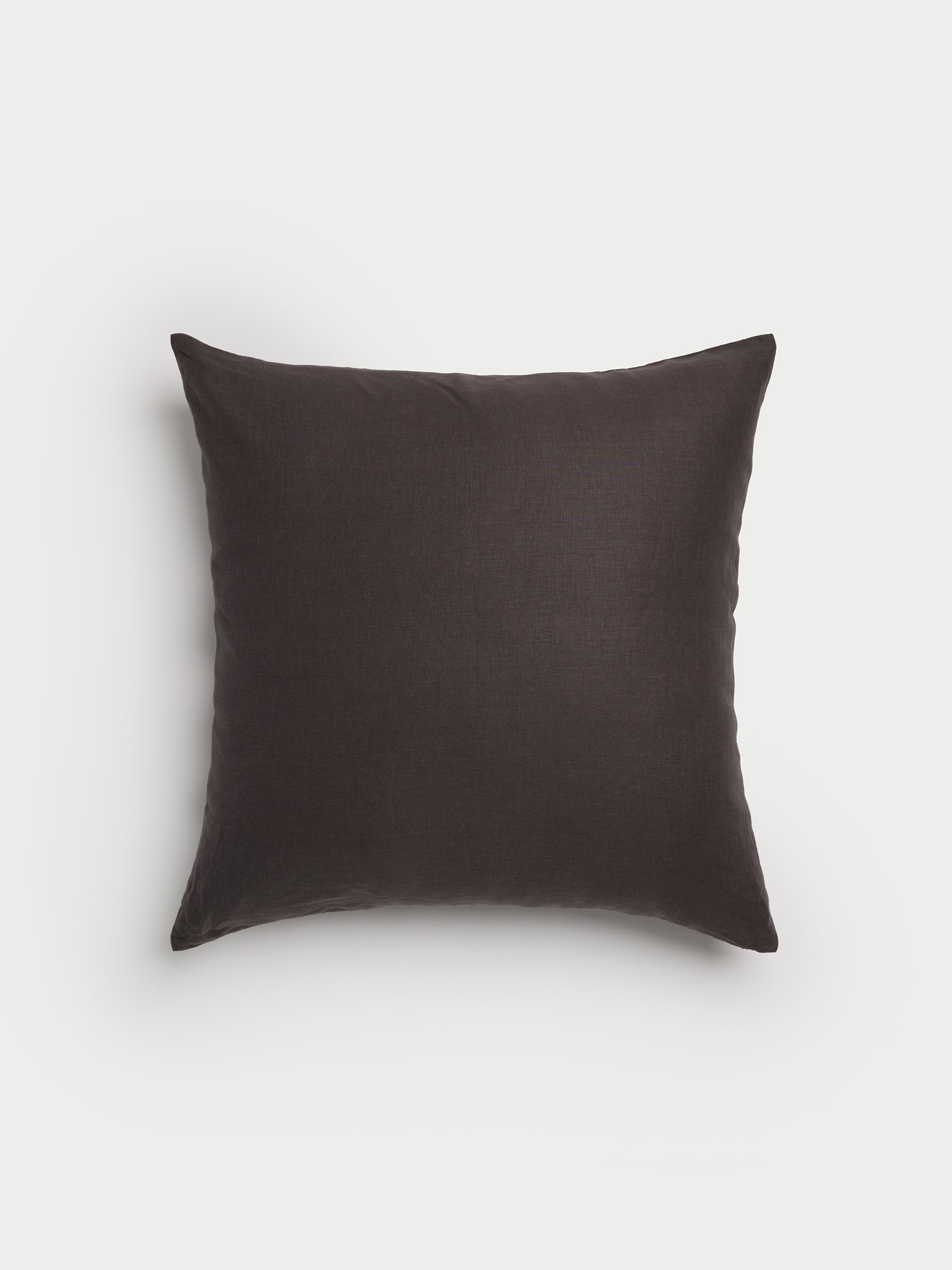 A square Linen Throw Pillow by Cozy Earth, in a dark brown hue with a smooth fabric texture, set against a plain white background. |Color:Coal|Size:24" x 24"