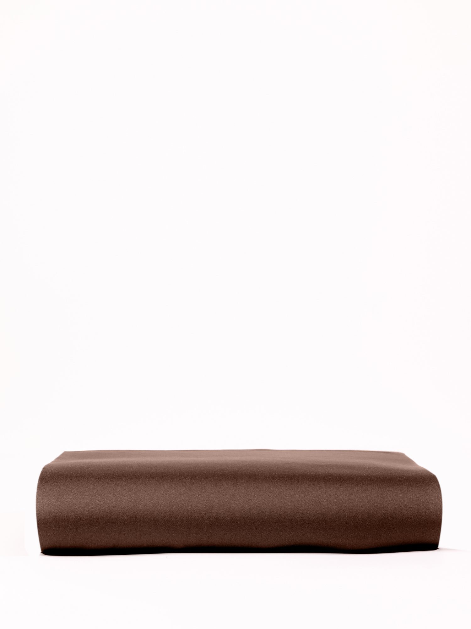 A neatly folded Cozy Earth Bamboo Fitted Sheet in a soft brown shade is placed against a plain white background. The sheet features a smooth texture and clean edges, enhancing its tidy appearance. |Color:Coffee