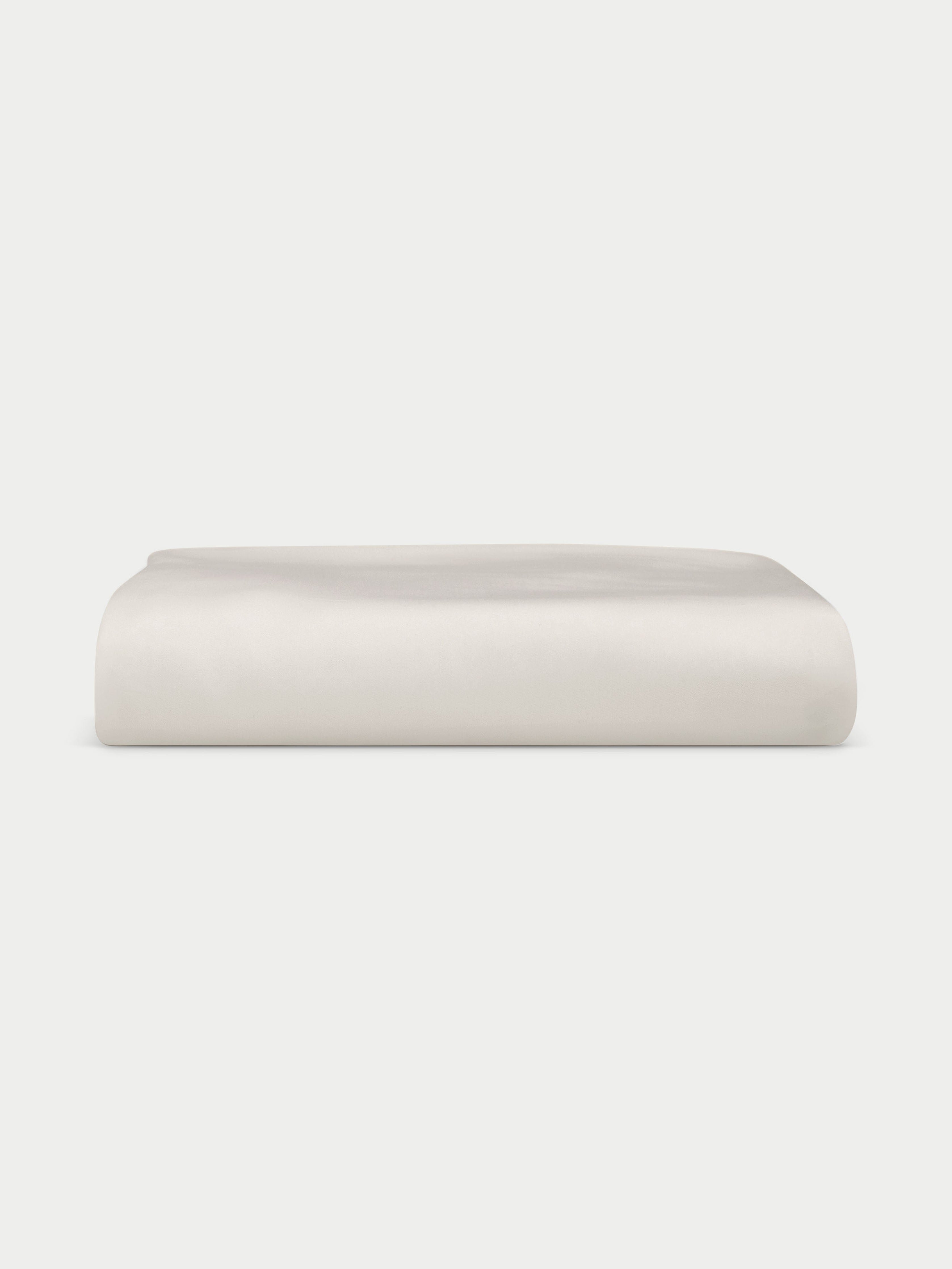 Creme fitted sheet folded with a white background 