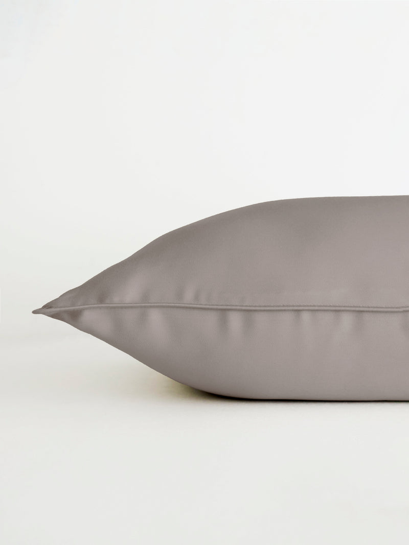 Close-up of Cozy Earth's Bamboo Travel Pillowcase on a white background. The grey pillowcase is shown from the side, highlighting the smooth texture and subtle sheen of its fabric.