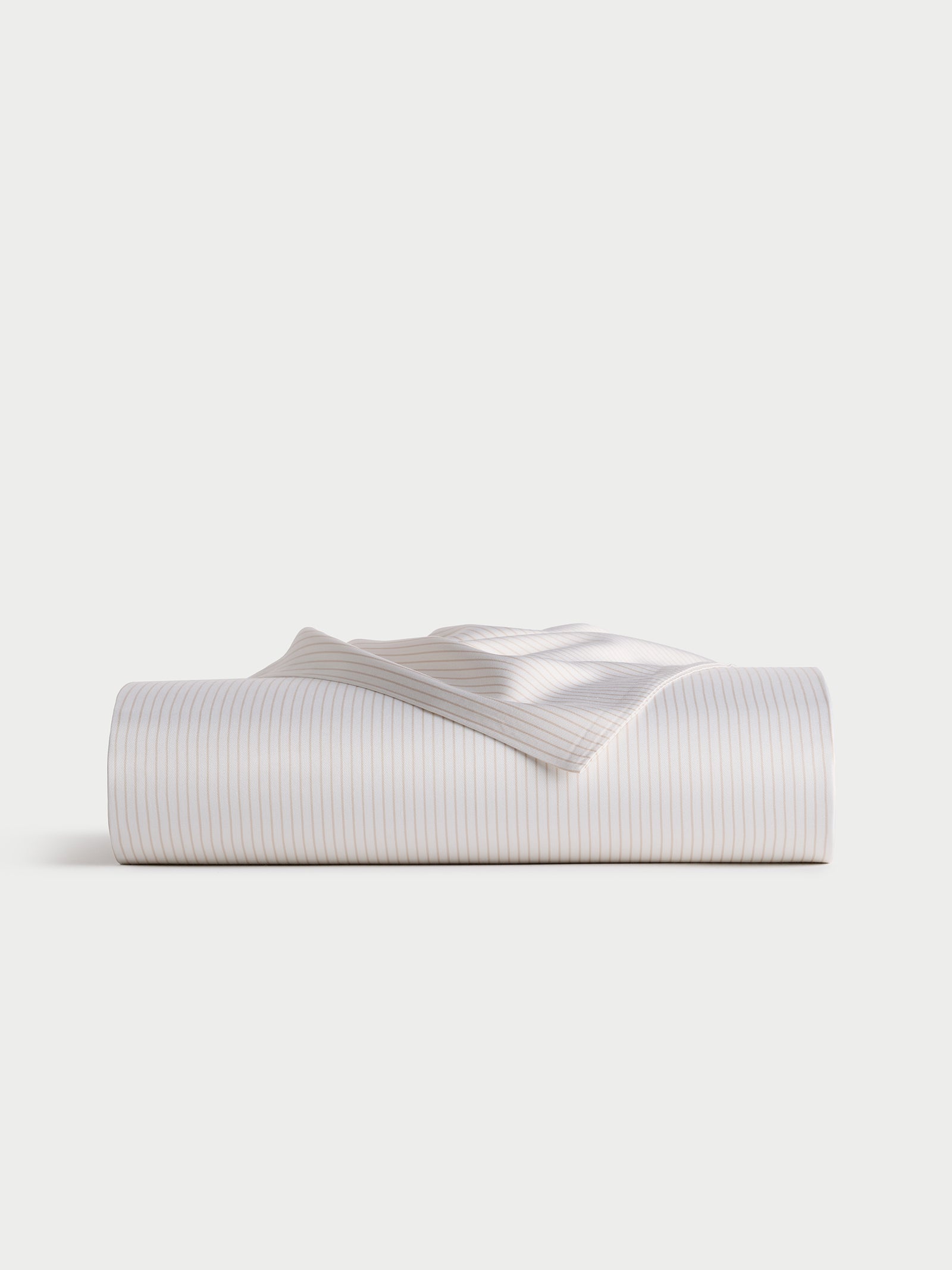 Displayed against a plain, light background is the Bamboo Flat Sheet by Cozy Earth, neatly folded and featuring subtle, thin blue stripes on a white base. 