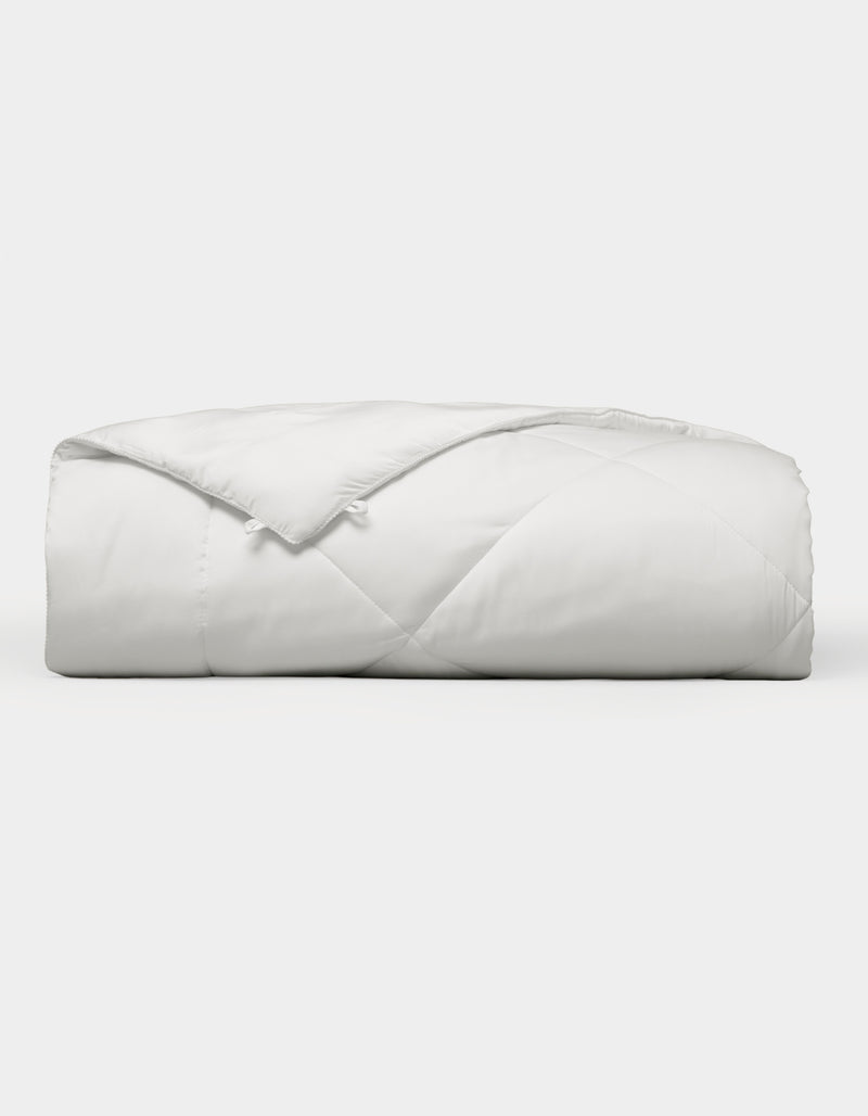 The Cozy Earth Bamboo Viscose Comforter, featuring a quilted design, is neatly folded and displayed against a plain white background.