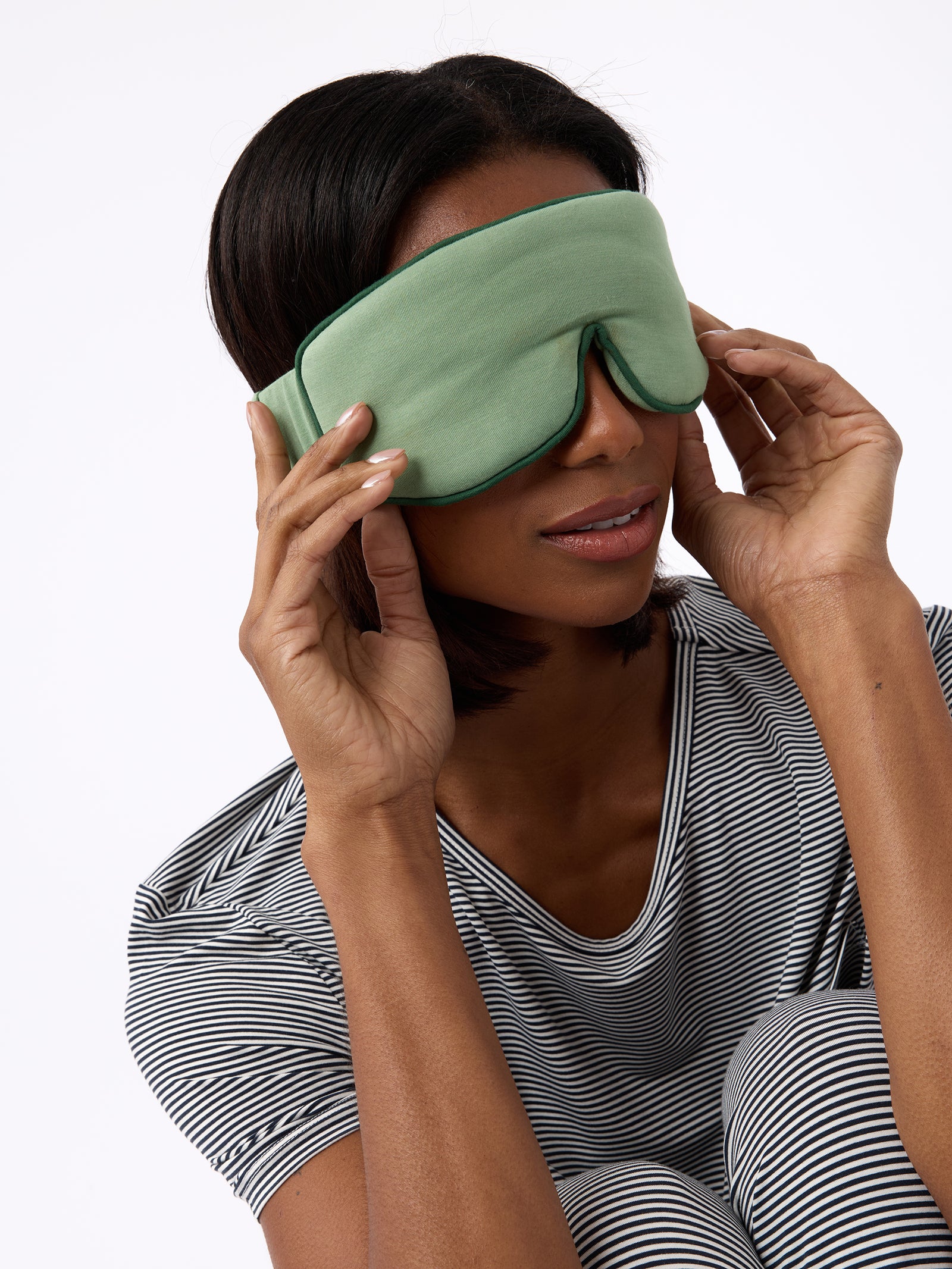 Woman wearing fern sleep mask with white background 