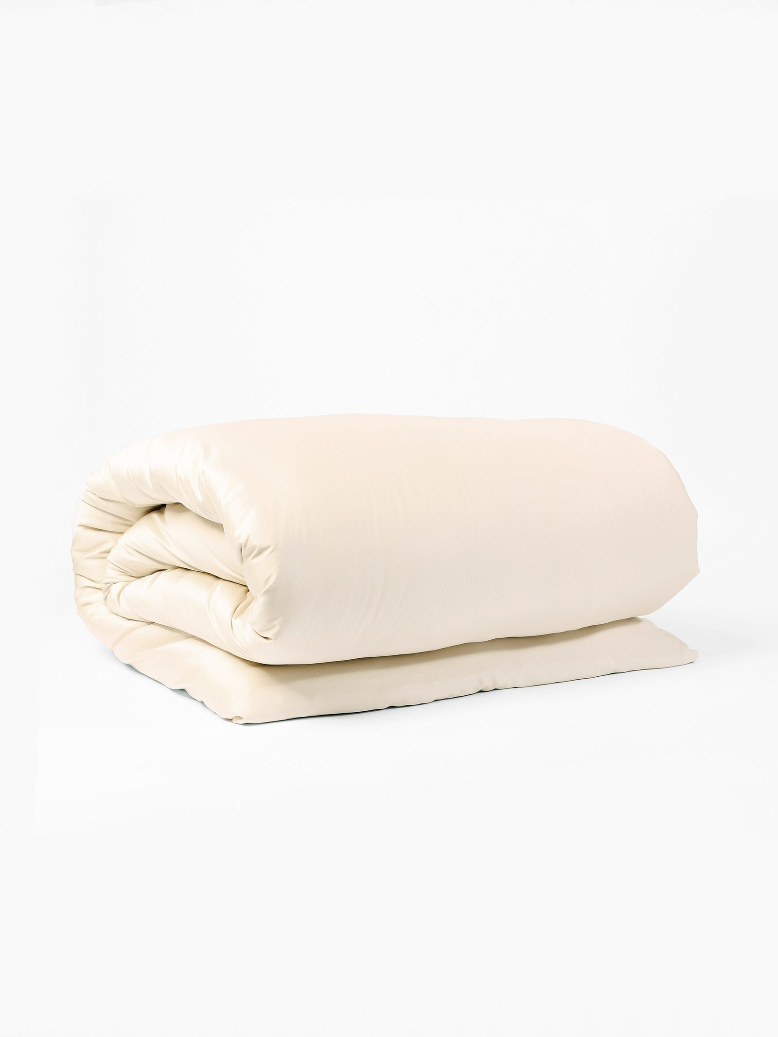 A neatly folded Bamboo Duvet Cover by Cozy Earth lies against a plain white background. The cream-colored duvet showcases its soft and smooth texture, suggesting it is plush and comfortable. The duvet appears clean and well-maintained, ready for use. 