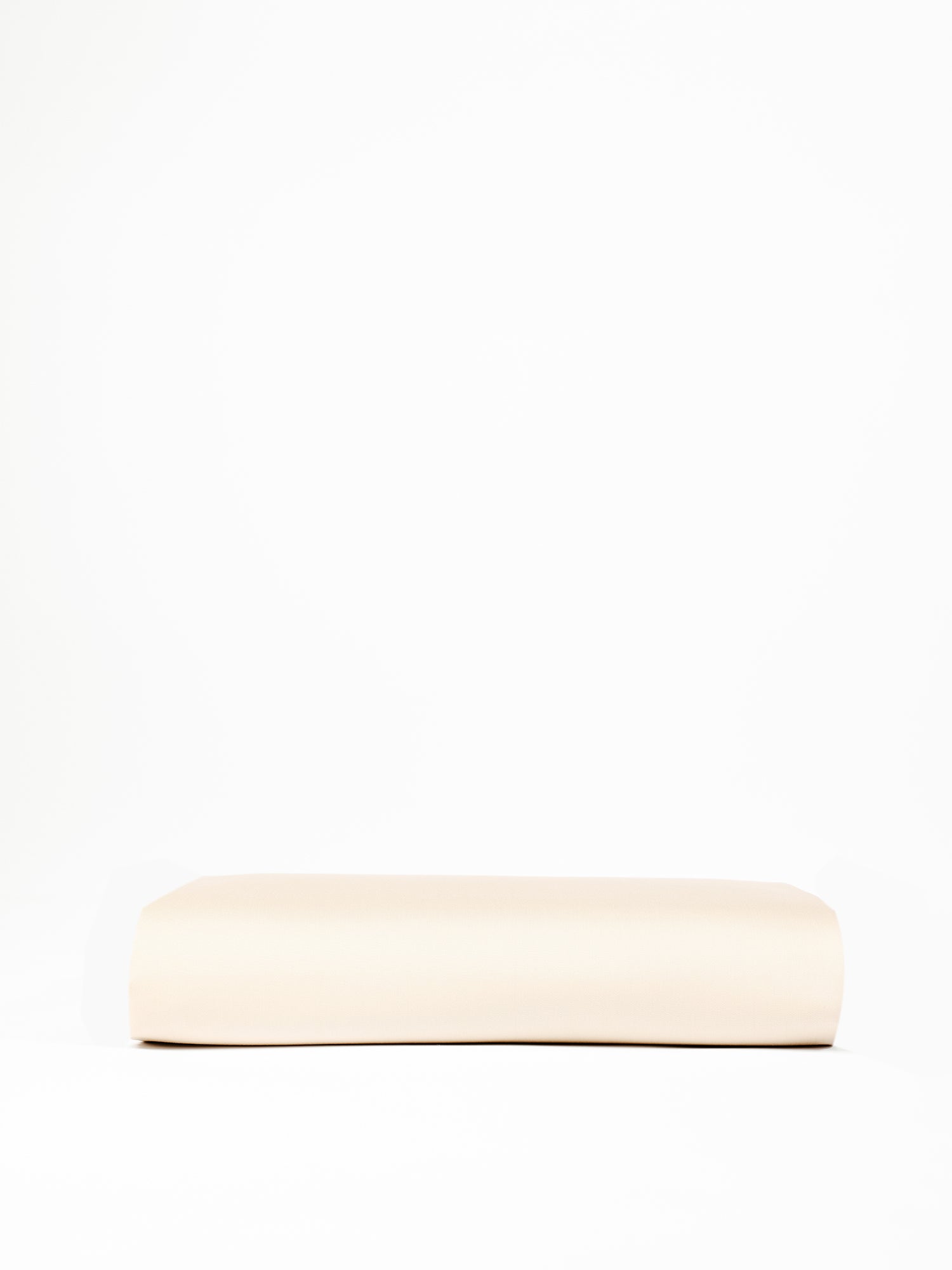 A Bamboo Fitted Sheet by Cozy Earth, featuring a rectangular beige design, is positioned against a plain white background. The sheet has a smooth, unadorned surface and appears plush and comfortable. |Color:Flax