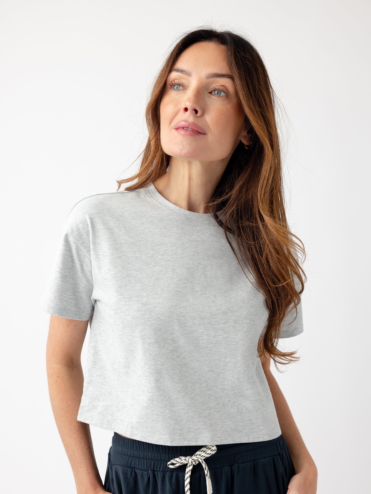 French Dove Heather All Day Cropped Tee. The photo of the All Day Cropped Tee is taken with a with a white background and is worn by a woman. |Color:French Dove Heather