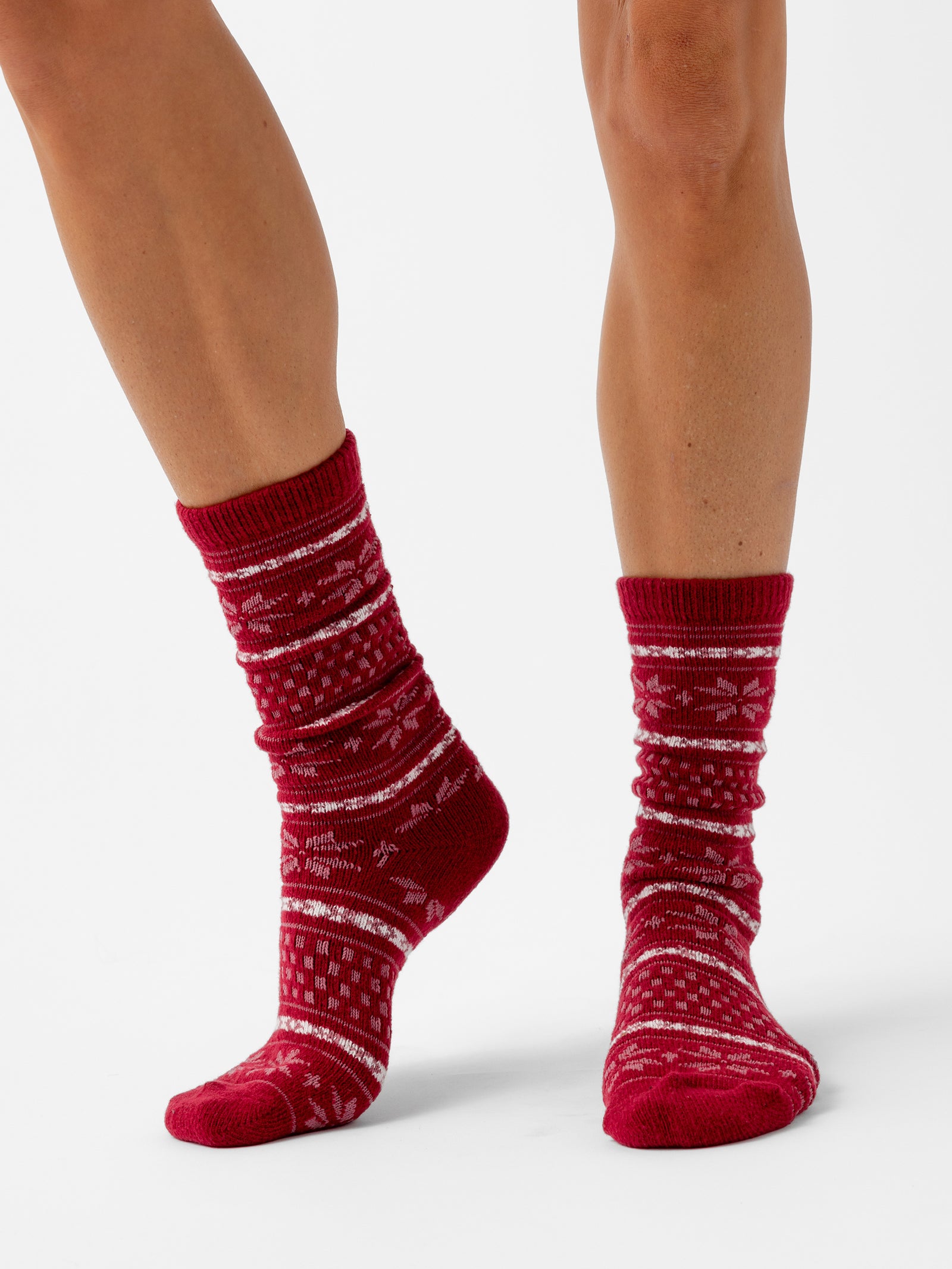 A person stands with a white background wearing Snowflake Plush Lounge Sock in Garnet 