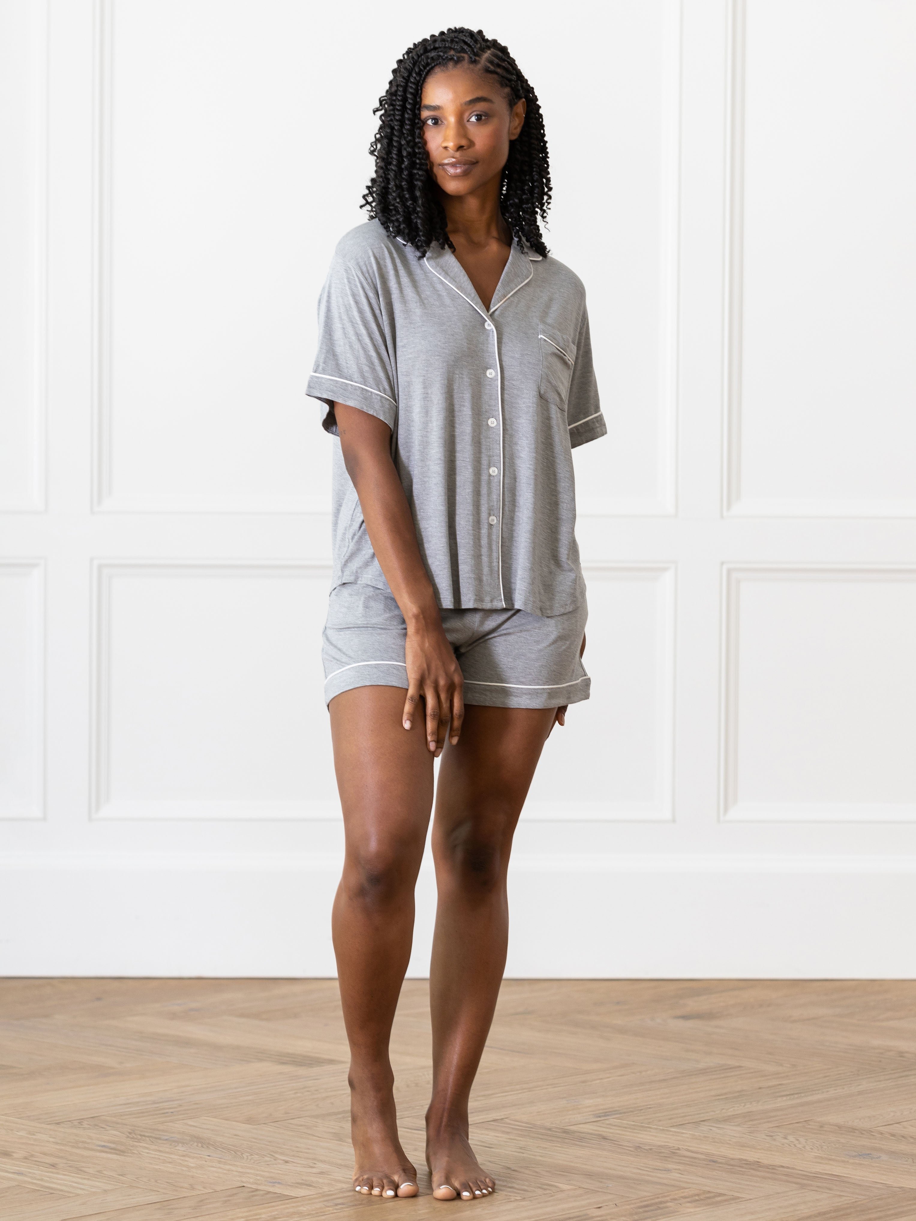 Grey Short Sleeve Pajama Set modeled by a woman. The photo was taken in a light setting, showing off the colors and lines of the pajamas. 