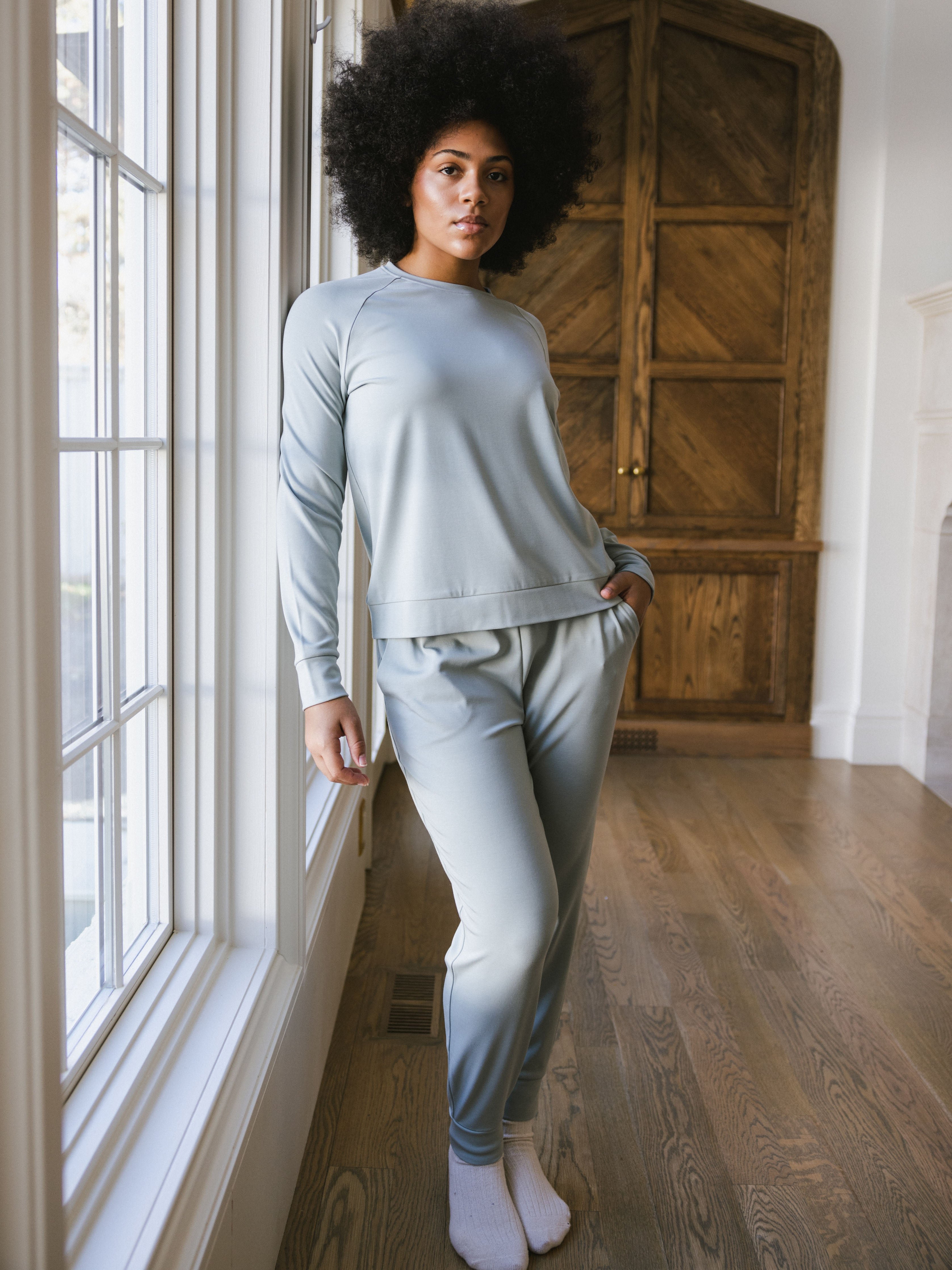Haze Bamboo Jogger Set modeled by a woman. The photo was taken in a high contrast setting, showing off the colors and lines of the pajamas. 
