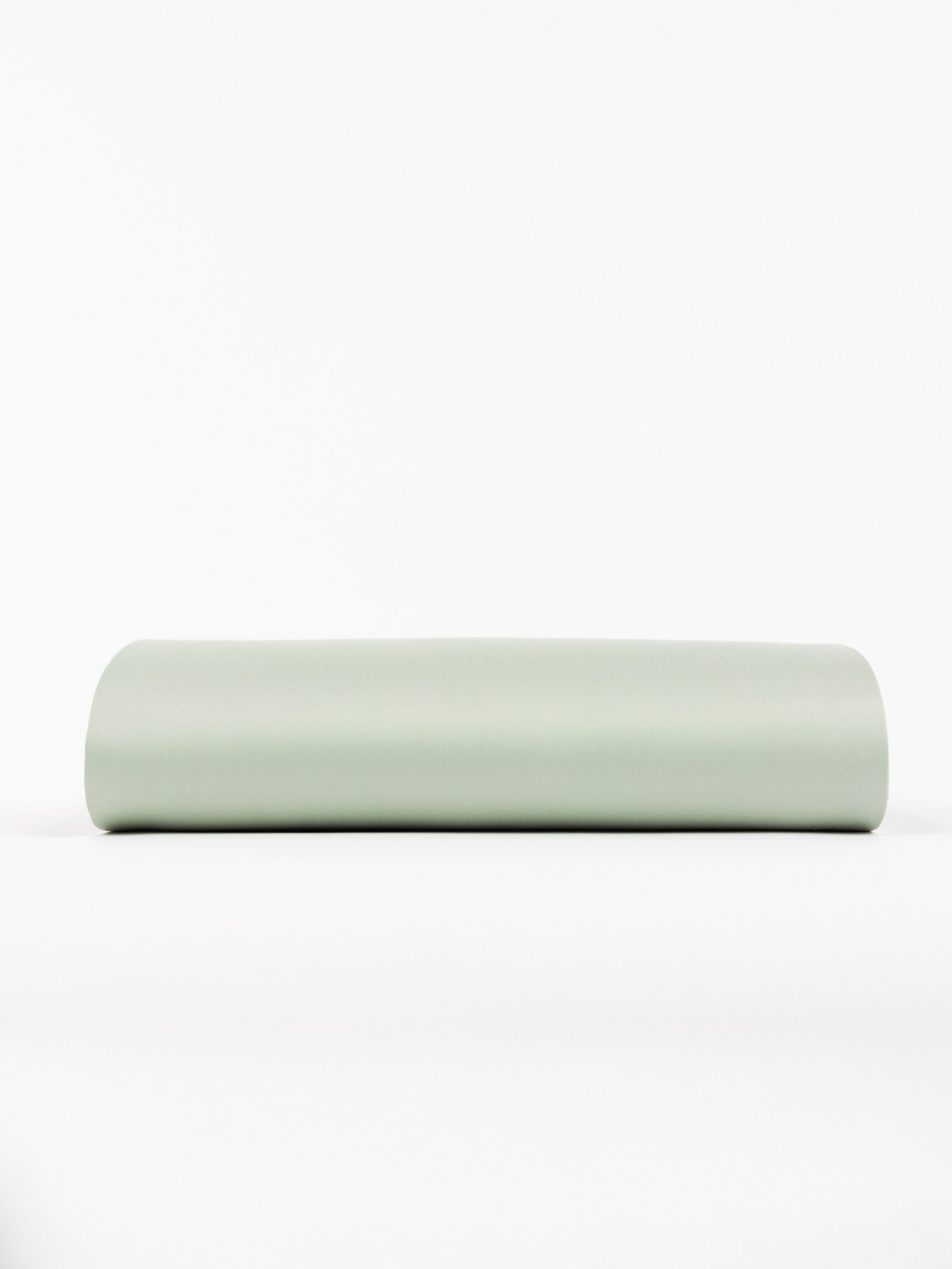 A Cozy Earth Crib Sheet with a light green crib sheet is positioned horizontally against a white background. 