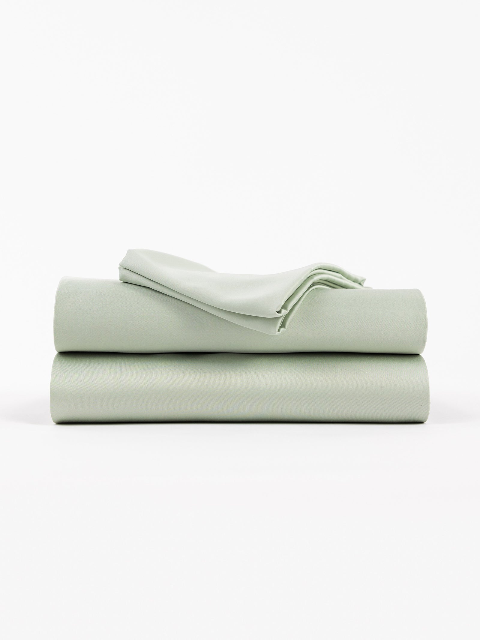 A neatly folded stack of Cozy Earth's Bamboo Sheet Set in Laurel against a white background features smooth, crisp sheets, including two larger pieces and one smaller folded top piece. 