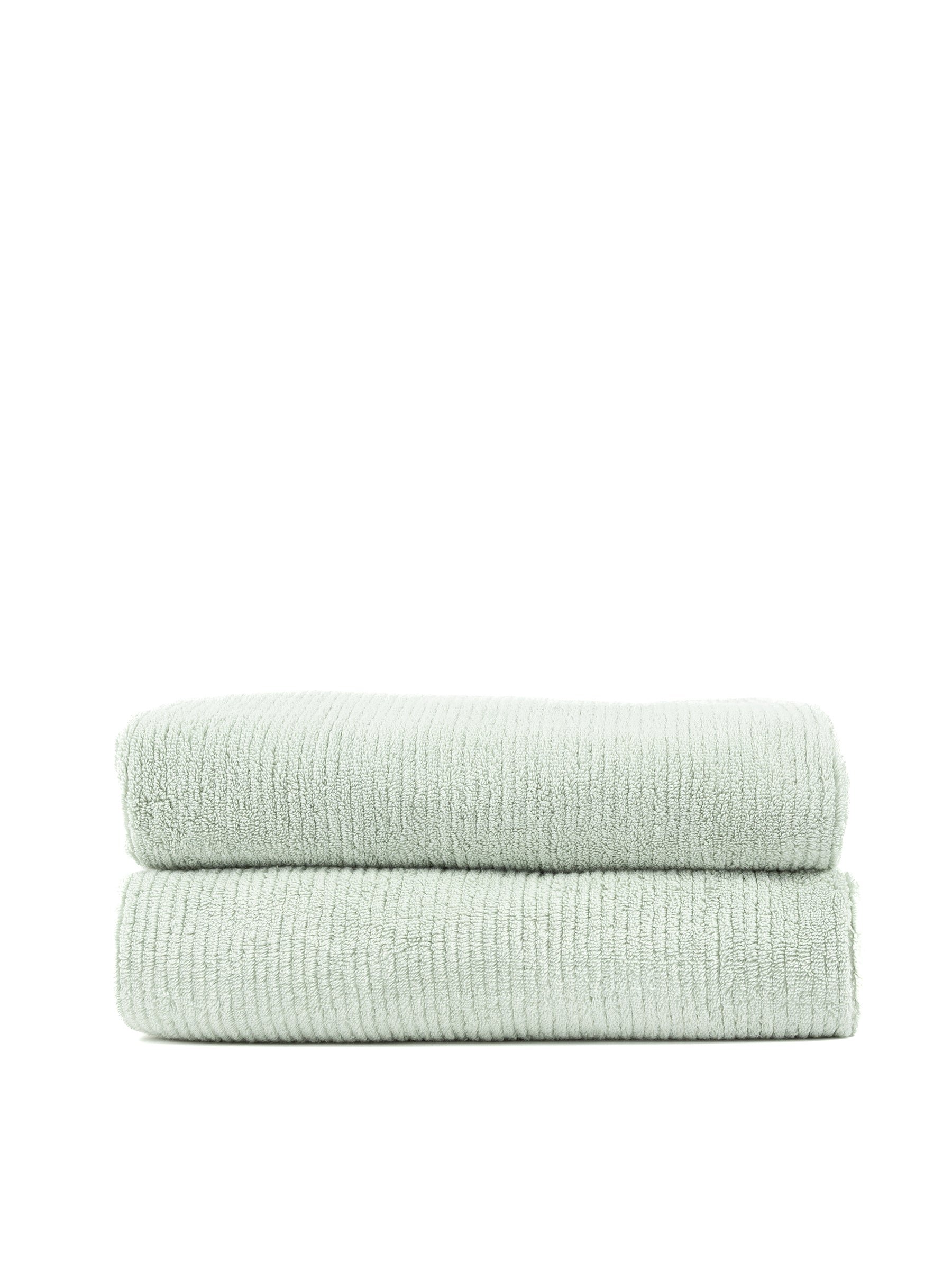 A stack of two neatly folded, light green Ribbed Terry Bath Towels by Cozy Earth. The towels appear soft and absorbent, boasting a ribbed texture on the surface, placed on a plain white background. |Color:Laurel