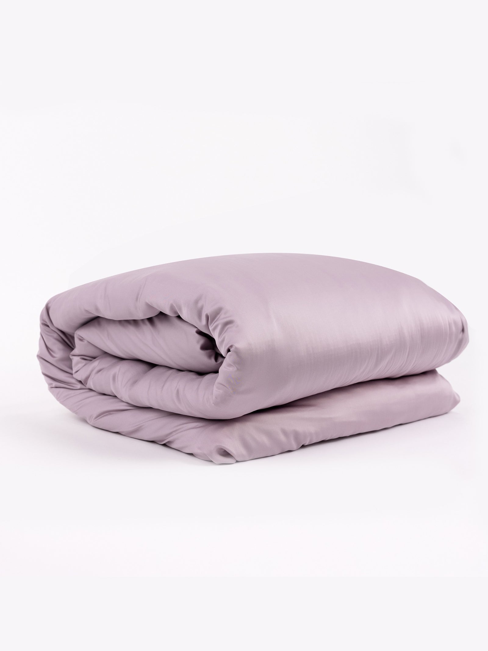 A neatly folded, soft lavender Bamboo Duvet Cover by Cozy Earth rests against a plain white background. The silky, smooth texture of the fabric enhances its luxurious appearance. 