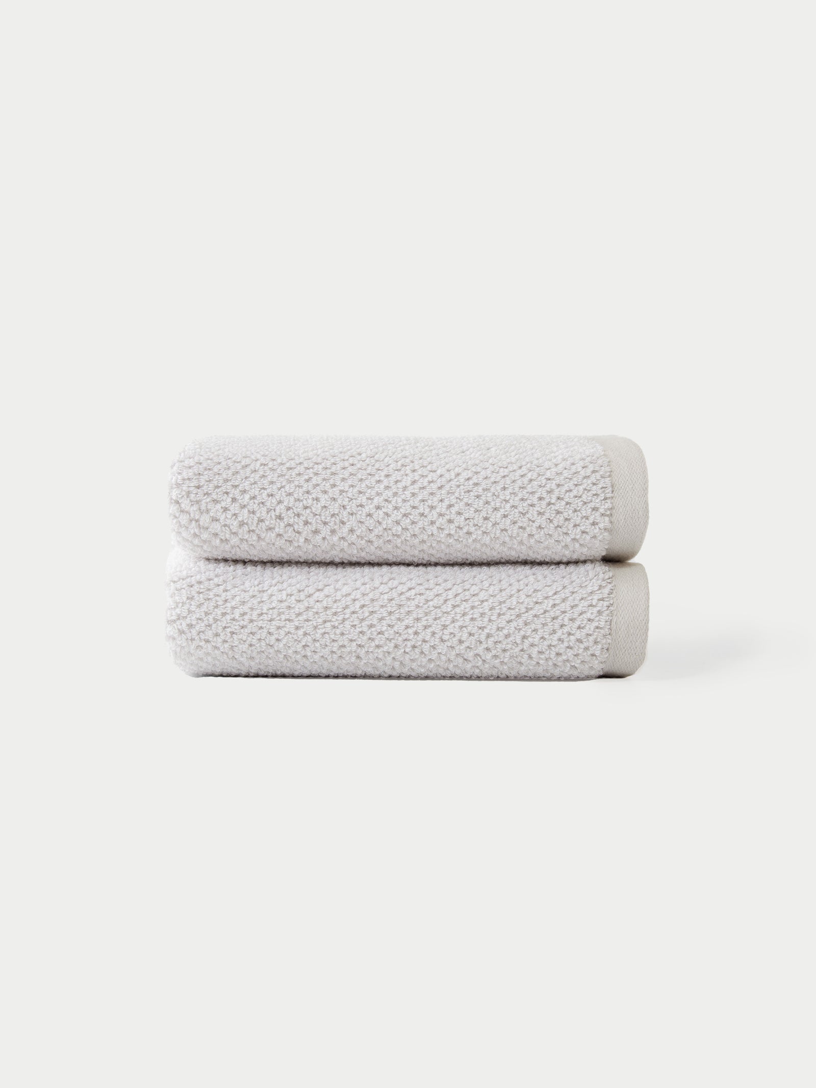 "Nantucket Hand Towels in the color Heathered Light Grey. The Hand Towels are neatly folded. The photo of the Hand Towels was taken with a white background.