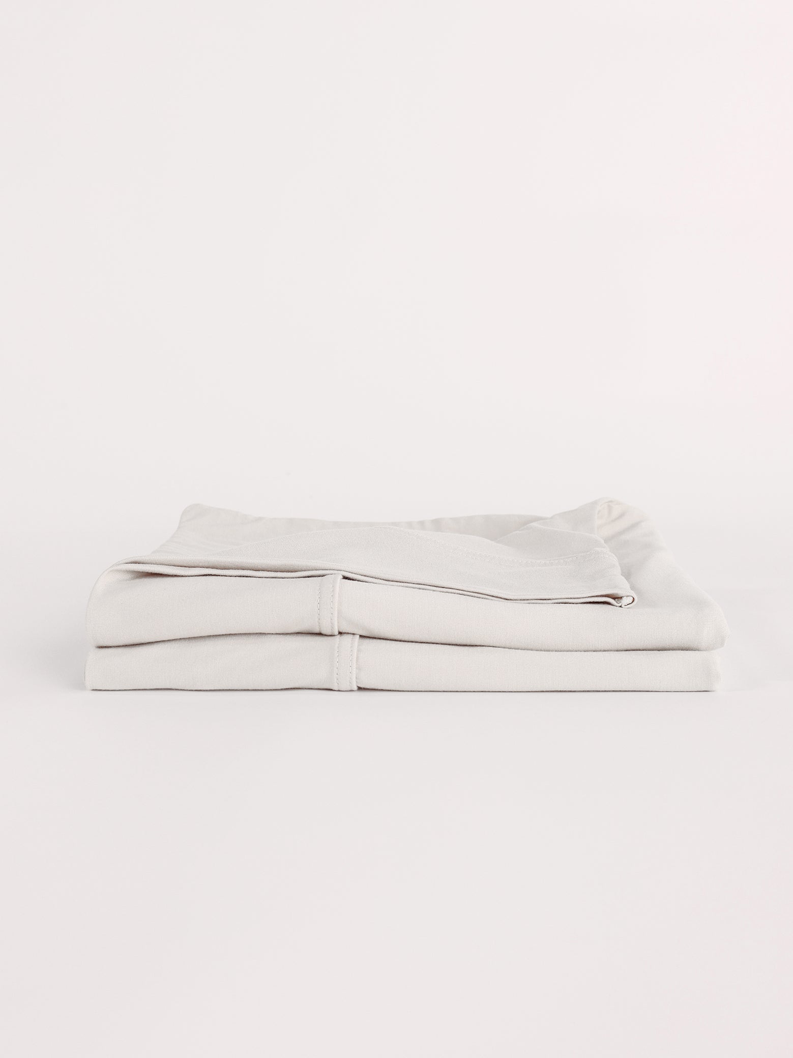 Light grey pillowcases folded with white background 