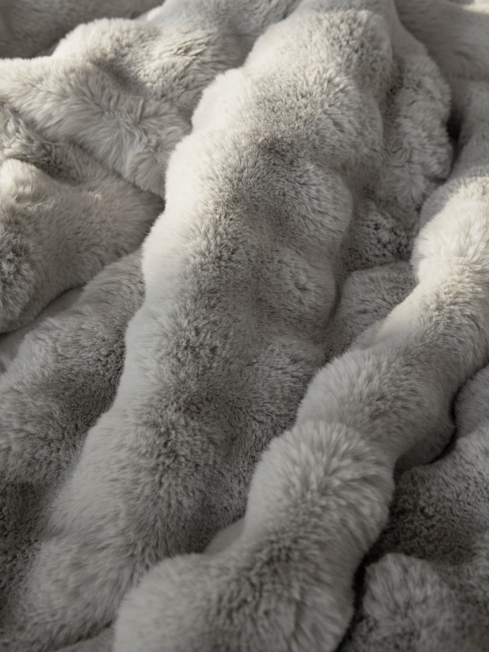 Close up of light grey lush faux fur blanket 