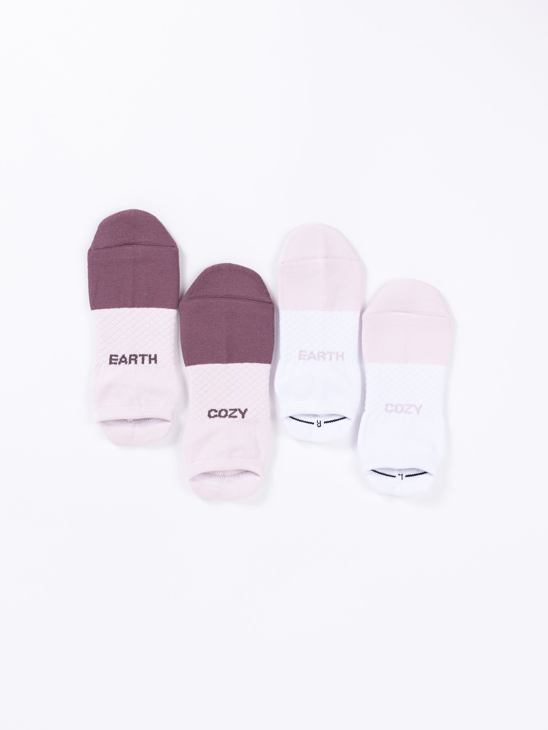 Four pairs of Cozy Earth's Essential Ankle Socks are displayed on a white background. The first pair is dark purple, the second pair is light pink, the third pair is purple with "EARTH" written on the cuff, and the fourth pair is white with "COZY" written on the cuff. |Color:Lilac