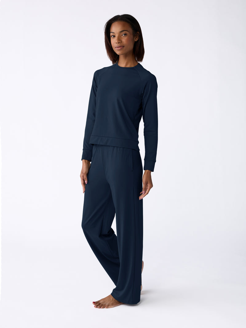 A person is barefoot against a plain white background wearing the Cozy Earth Women's Ultra-Soft Bamboo Wide Leg Pull On Pant & Pullover Crew Set in dark blue.