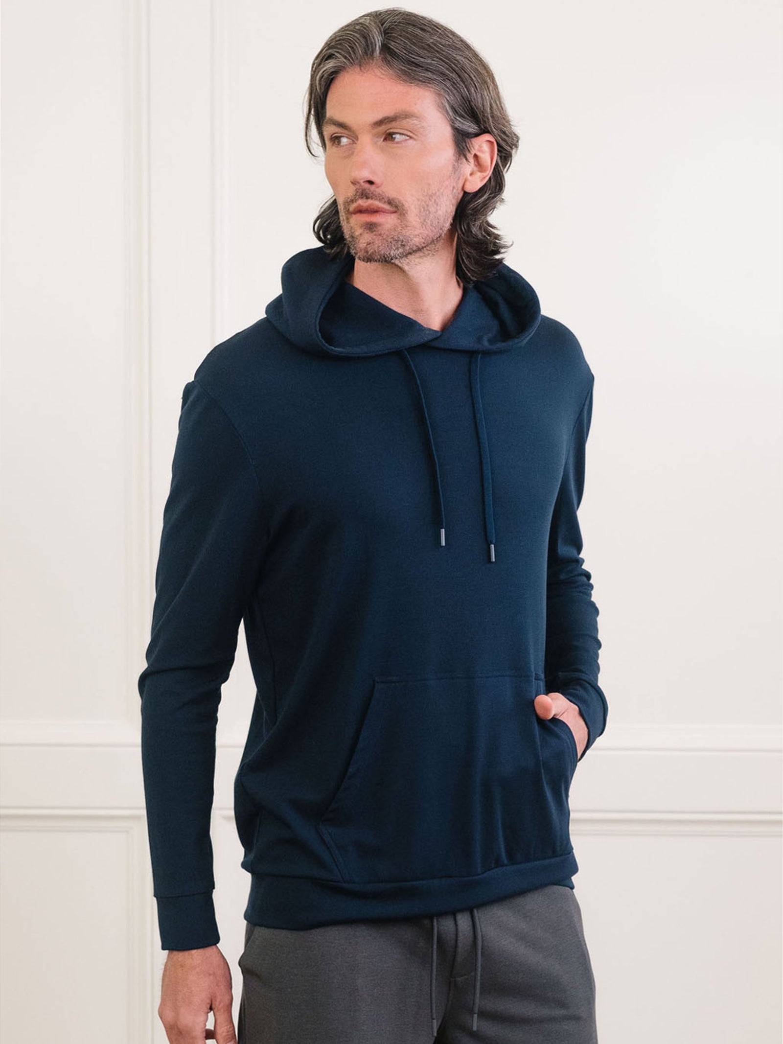 Navy Bamboo Hoodie worn by man standing in front of white background.
