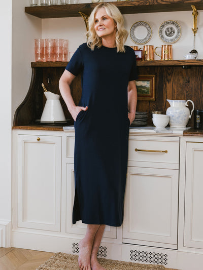 Navy Bamboo Midi Dress modeled by a woman. The photo was taken in a high contrast setting, showing off the colors and lines of the dress. |Color: Navy