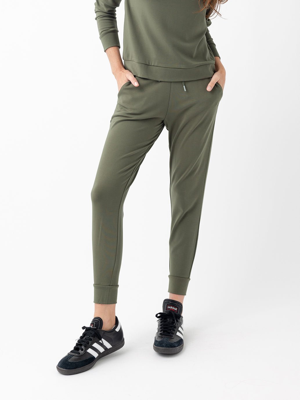 Woman in olive joggers with white background 