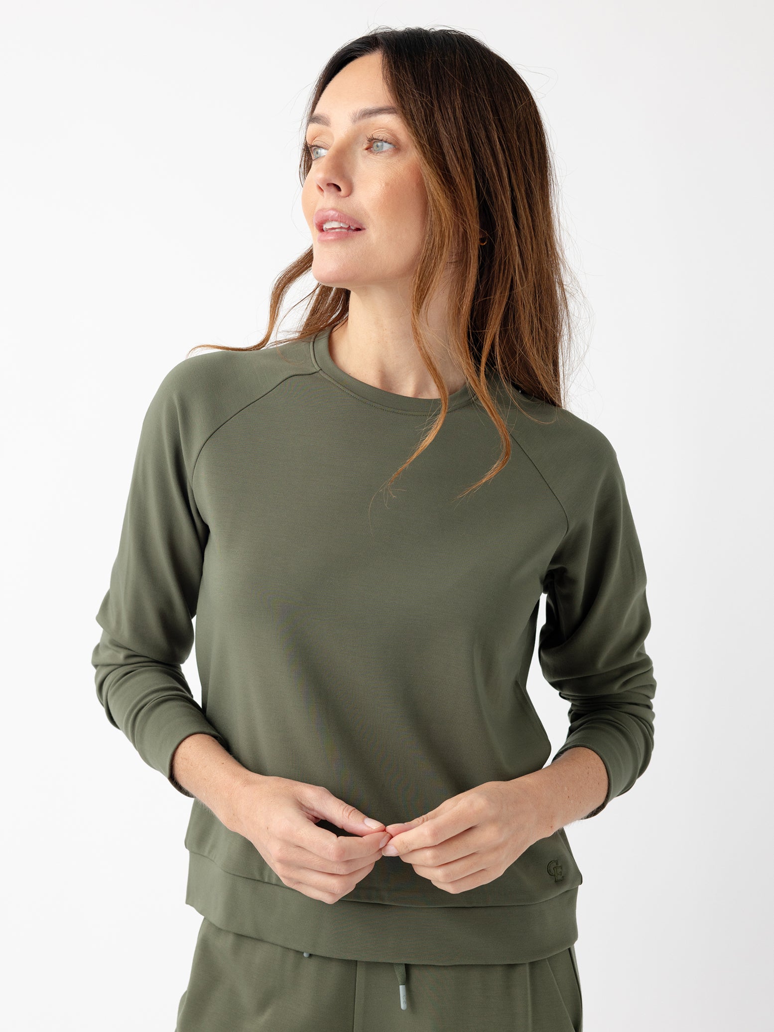 Woman in olive crewneck with white background 