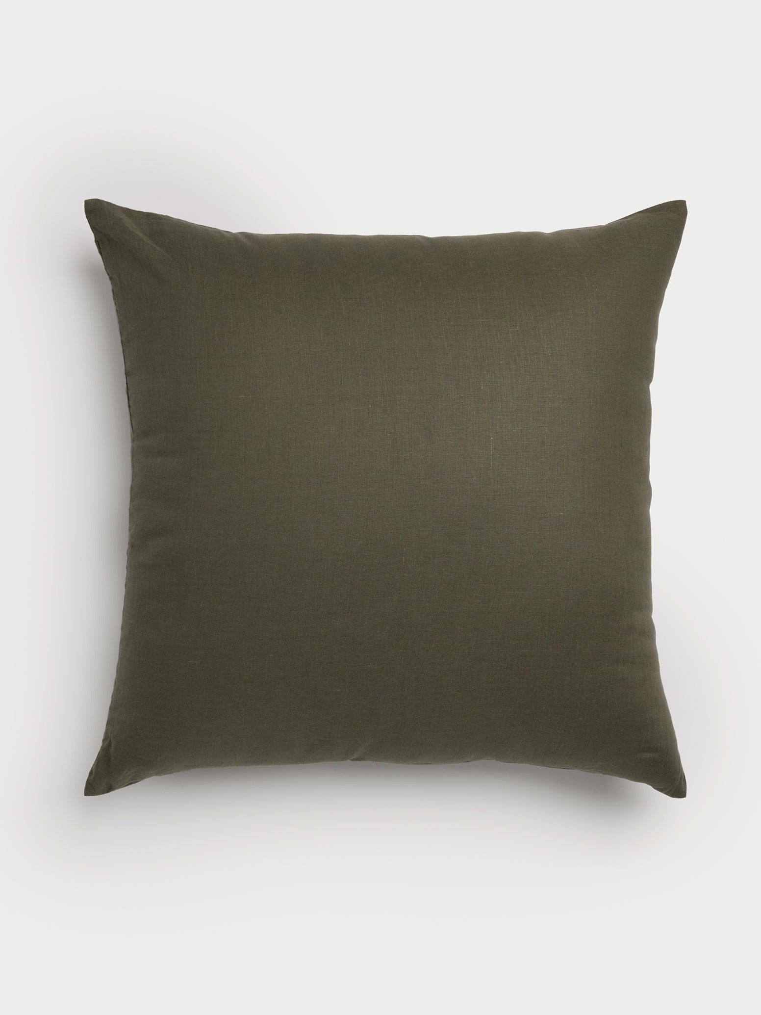 A square Linen Throw Pillow from Cozy Earth, featuring a dark green color and plain texture, is placed against a light, neutral backdrop. The pillow's pointed corners and smooth surface contribute to its simple yet elegant look. |Color:Olive|Size:26" x 26"