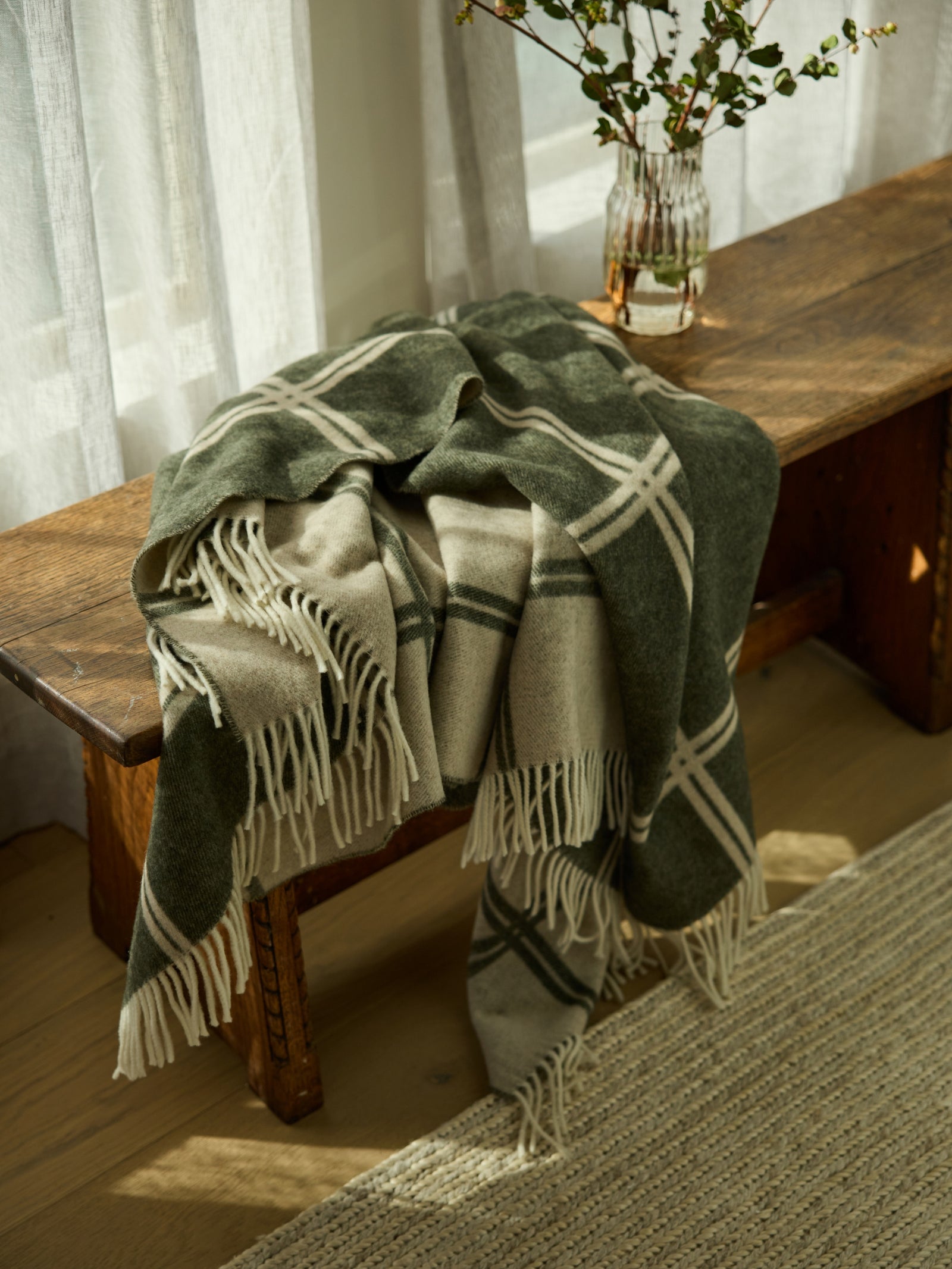 Olive cortina throw sitting on wooden bench 