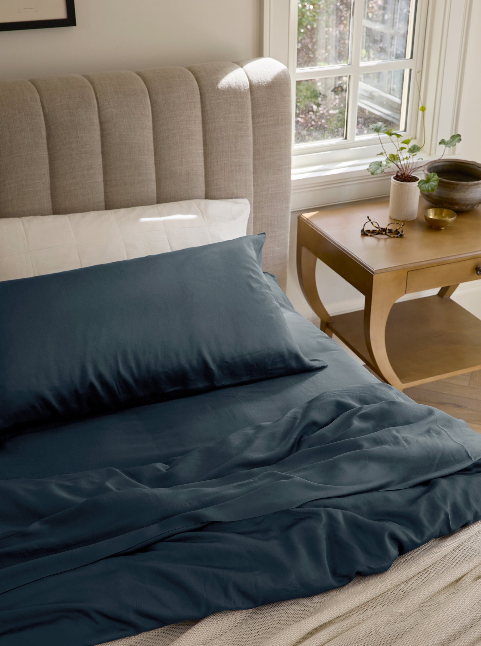 Unmade bed with pacific blue bedding 
