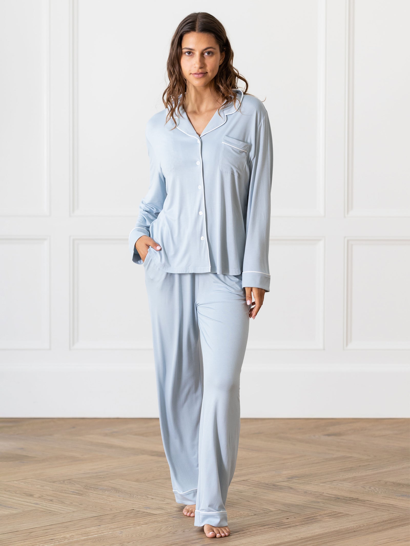 Powder Blue Long Sleeve Pajama Set modeled by a woman. The photo was taken in a high contrast setting, showing off the colors and lines of the pajamas. 
