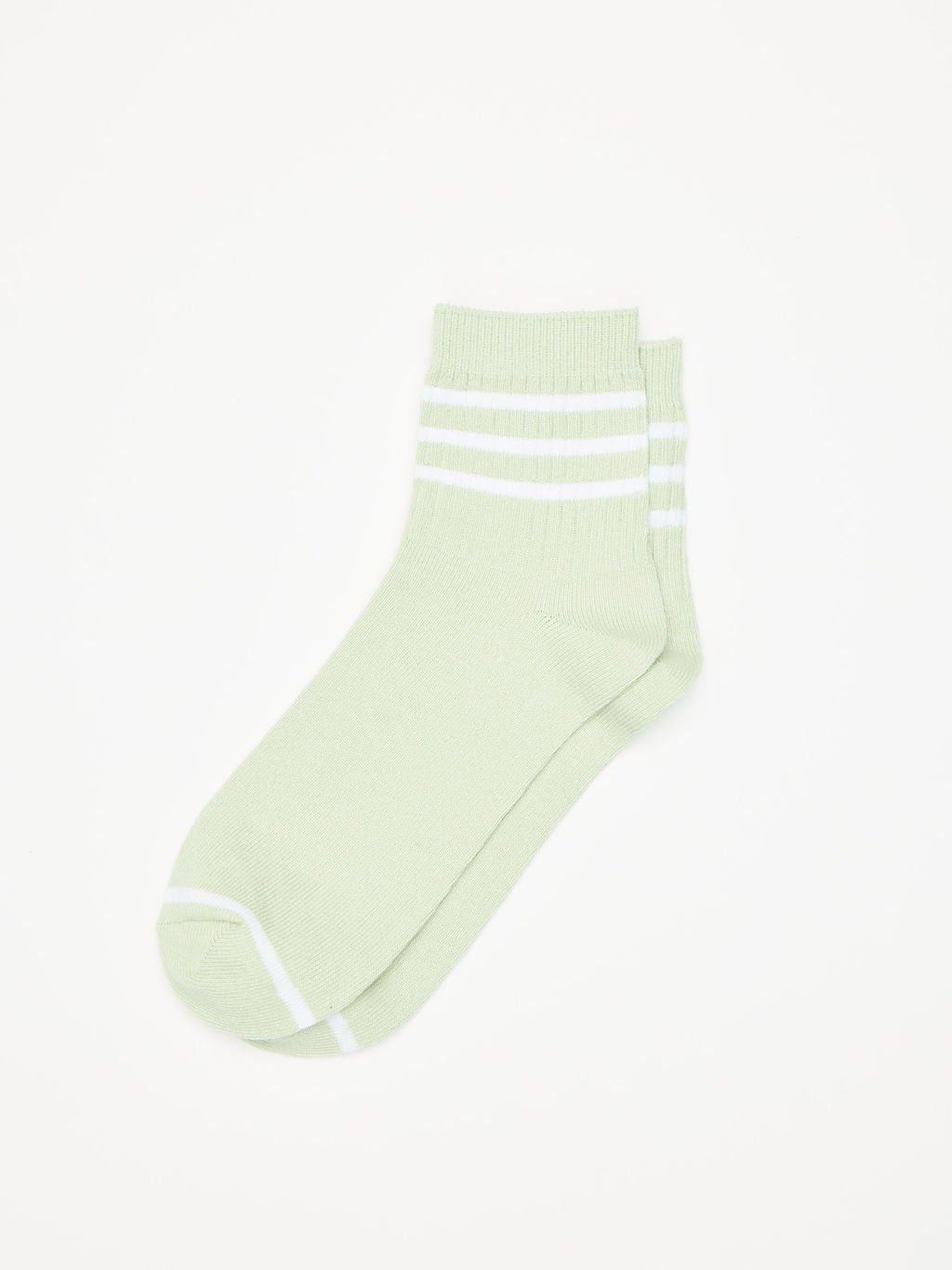 A single Women's Sadie Sock by Cozy Earth, light green with two white stripes near the top, is set against a plain white background. The heel and toe are in a slightly darker shade for subtle contrast. 