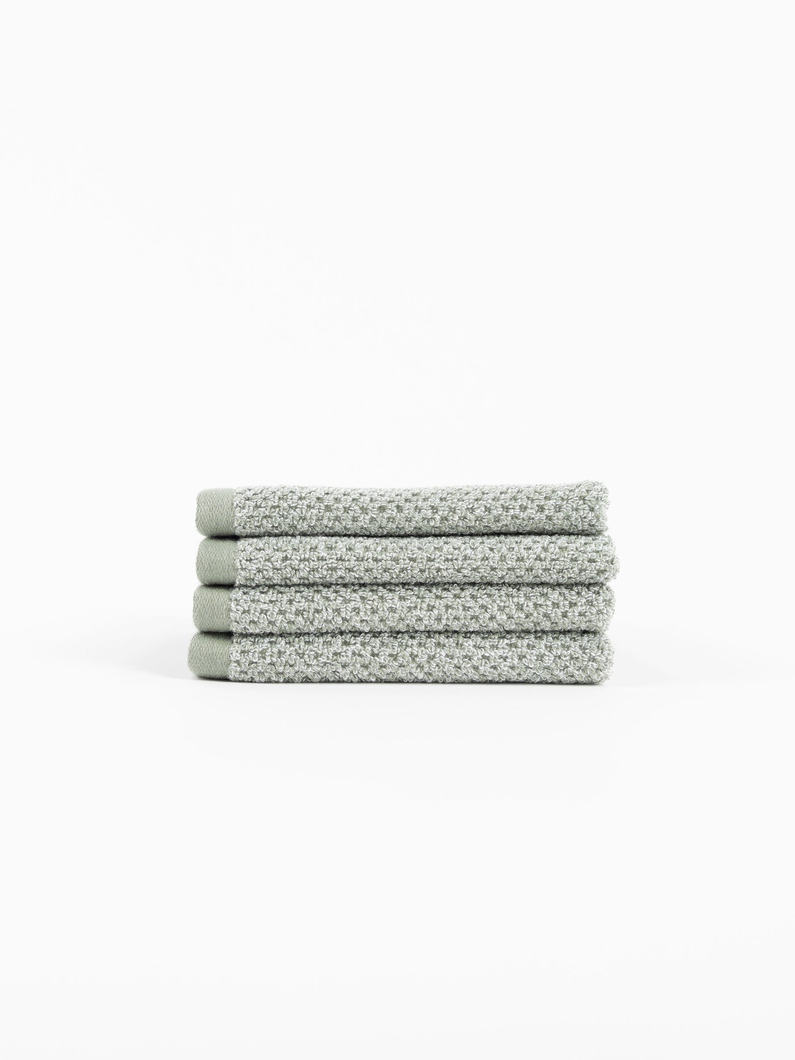 A neatly folded stack of four Cozy Earth Nantucket Bath Towels in textured light gray rests on a white background.