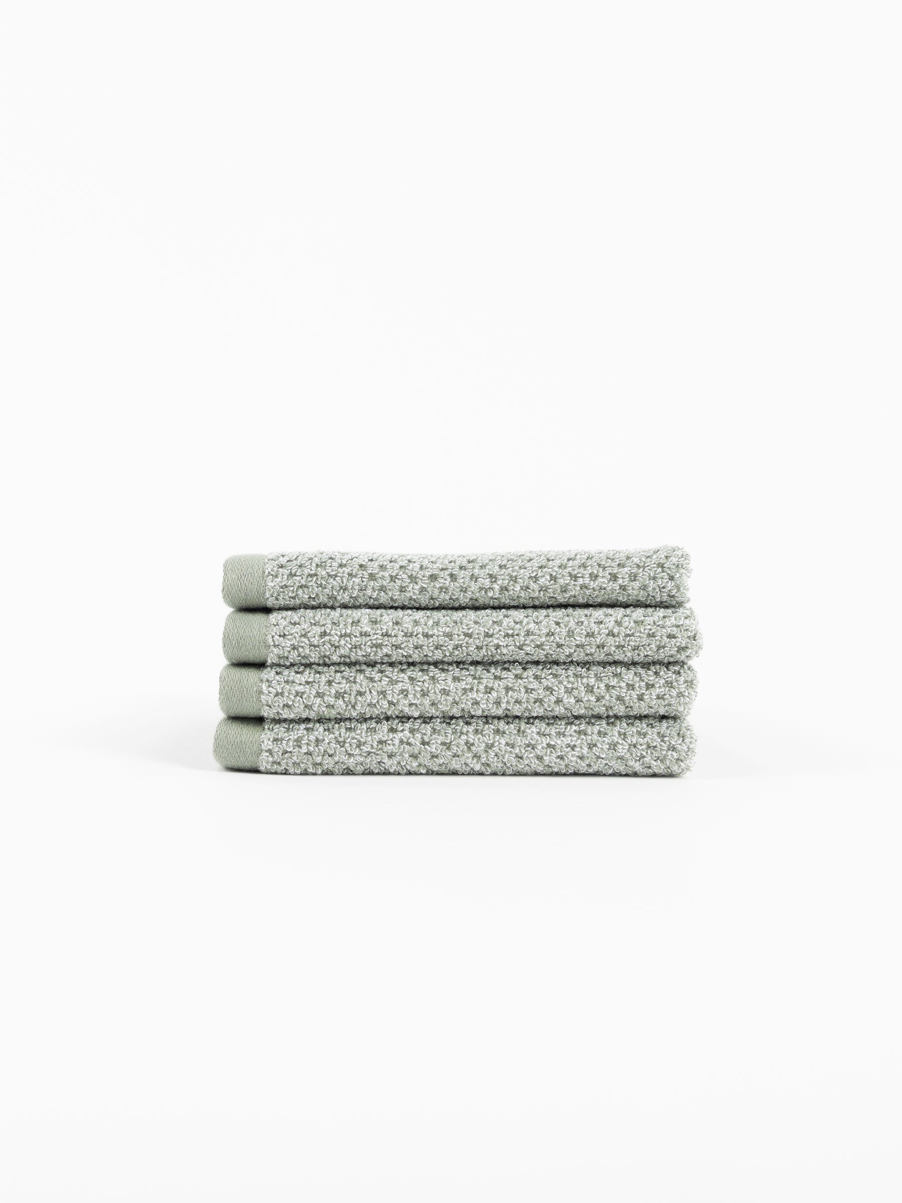 A stack of four Nantucket Washcloths in Heathered Sage sit in front of a white background. |Color:Heathered Sage