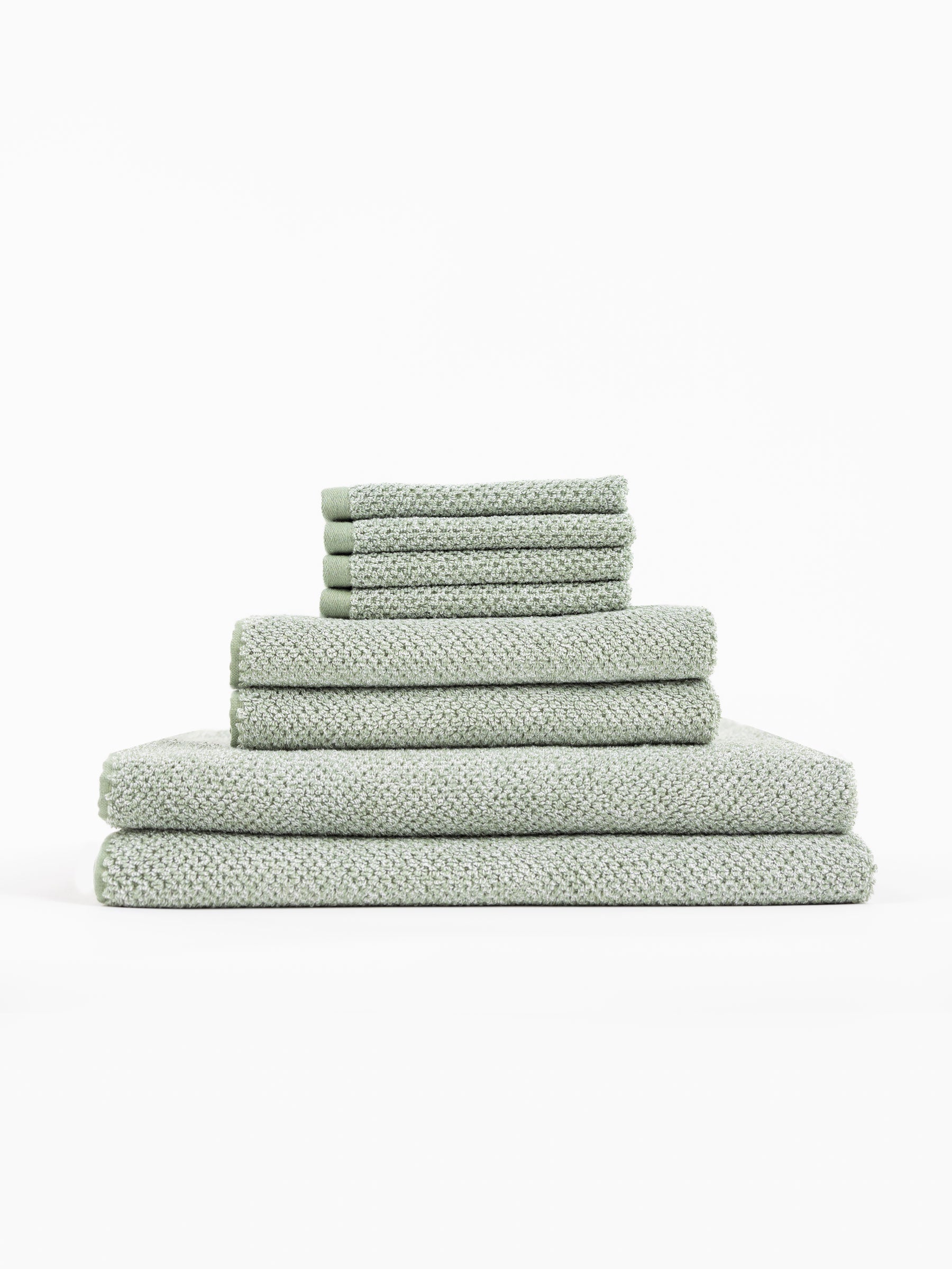 A stack of Nantucket Bath Towels sit in front of a white background. |Color:Heathered Sage