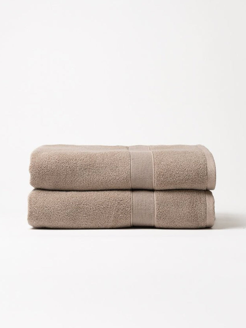 Sand luxe bath towels folded with white background