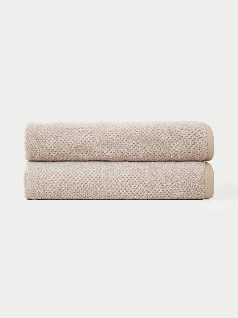 Two Nantucket Bath Towels by Cozy Earth are neatly folded and stacked together against a plain white background.