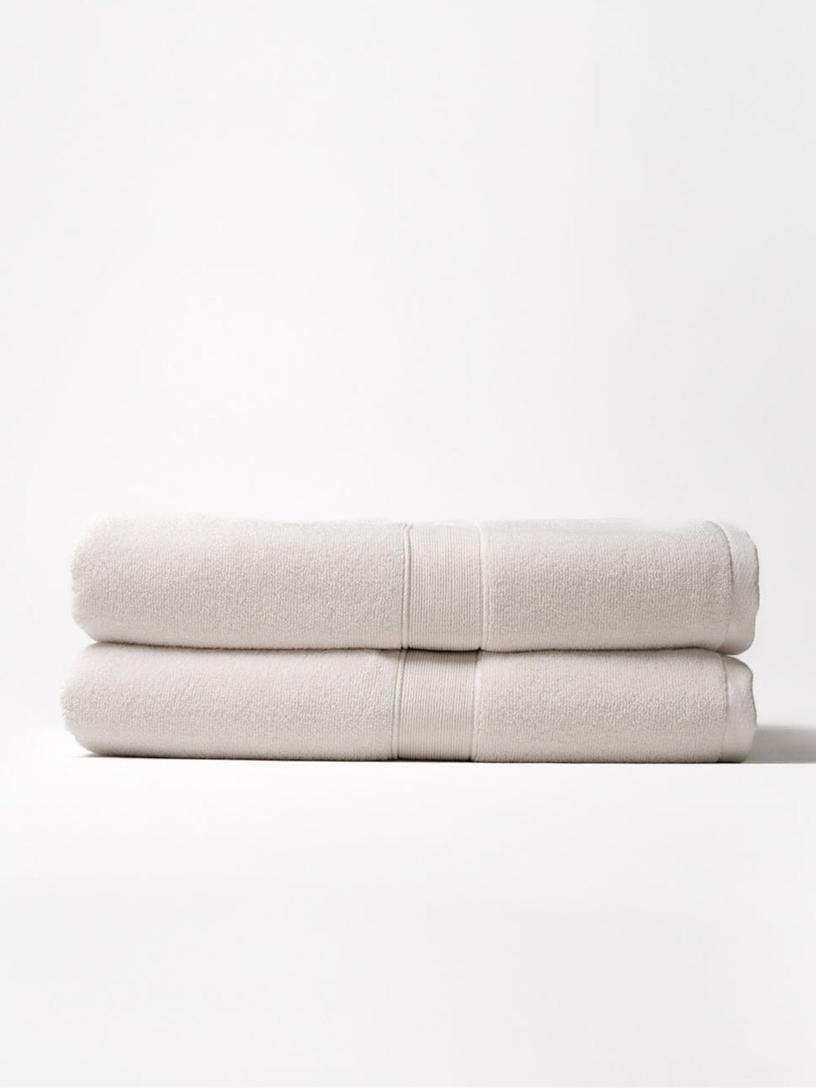 Two luxe bath sheets folded with white background 