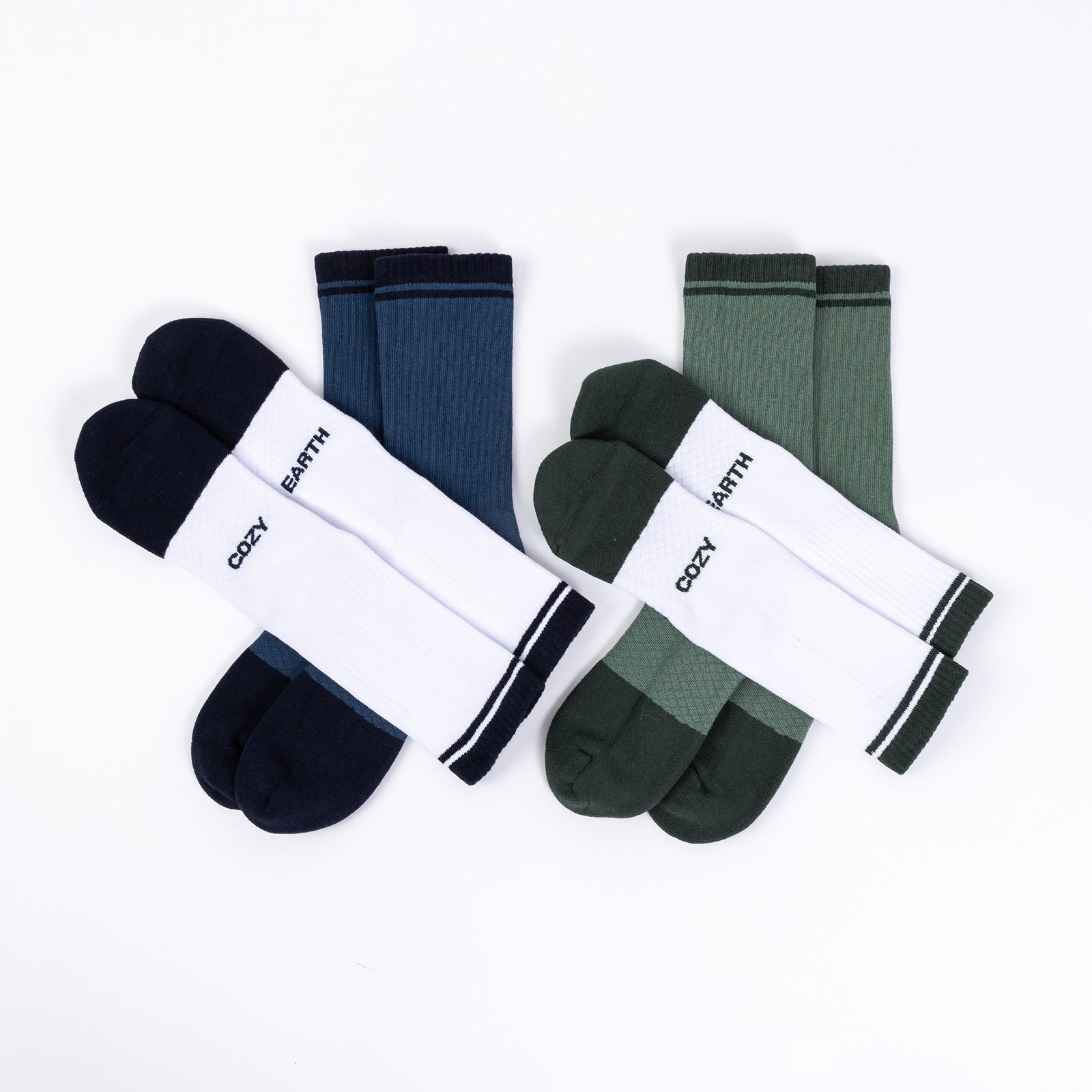 Four pairs of Cozy Earth socks are shown in the Essential Calf Sock 4-Pack. One pair is white with dark blue toes and heels, another is solid dark blue, a third pair is white with dark green toes and heels, and the fourth pair is solid dark green. 